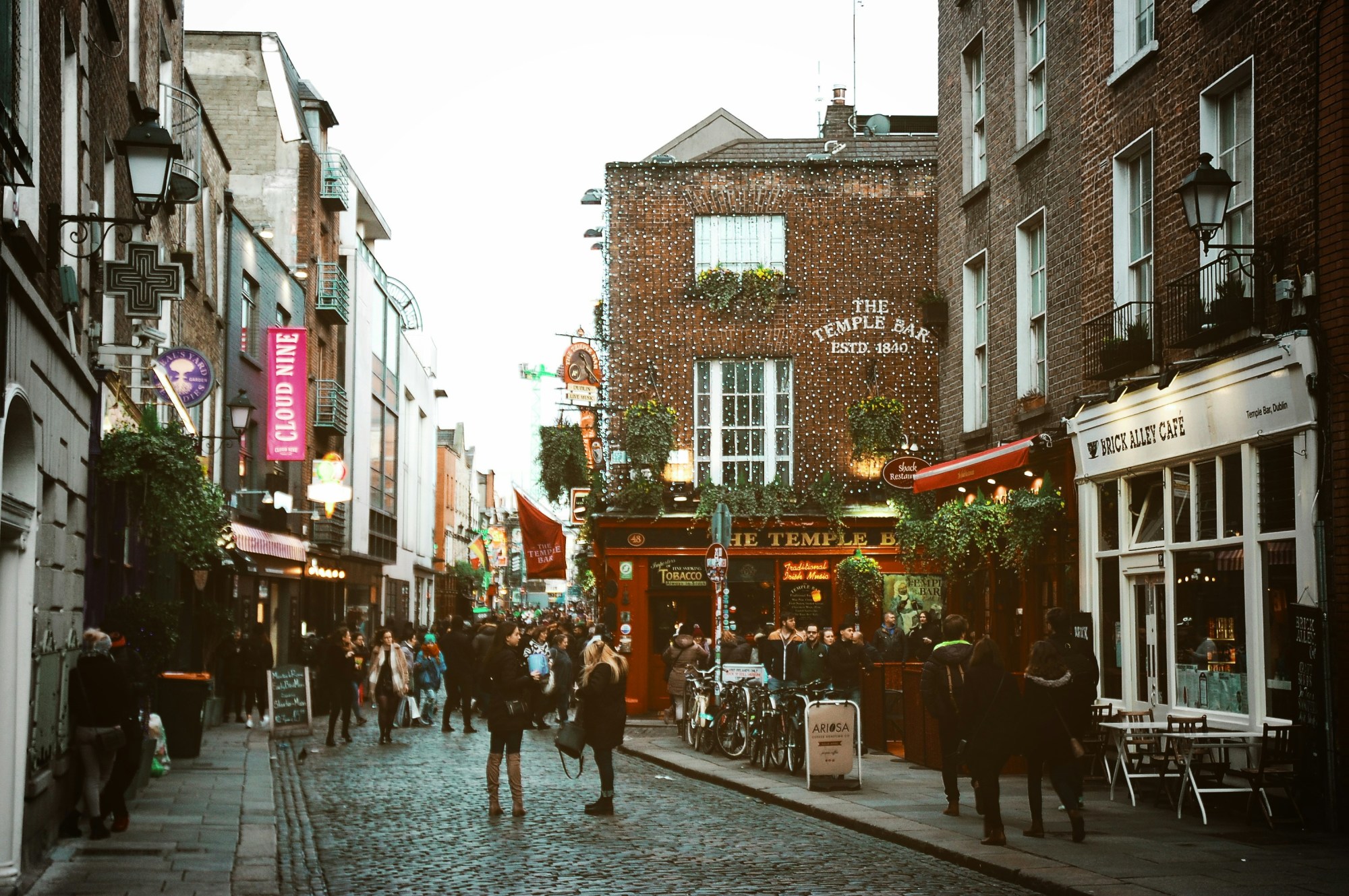 People walking on a cobblestone street near the Temple Bar.
