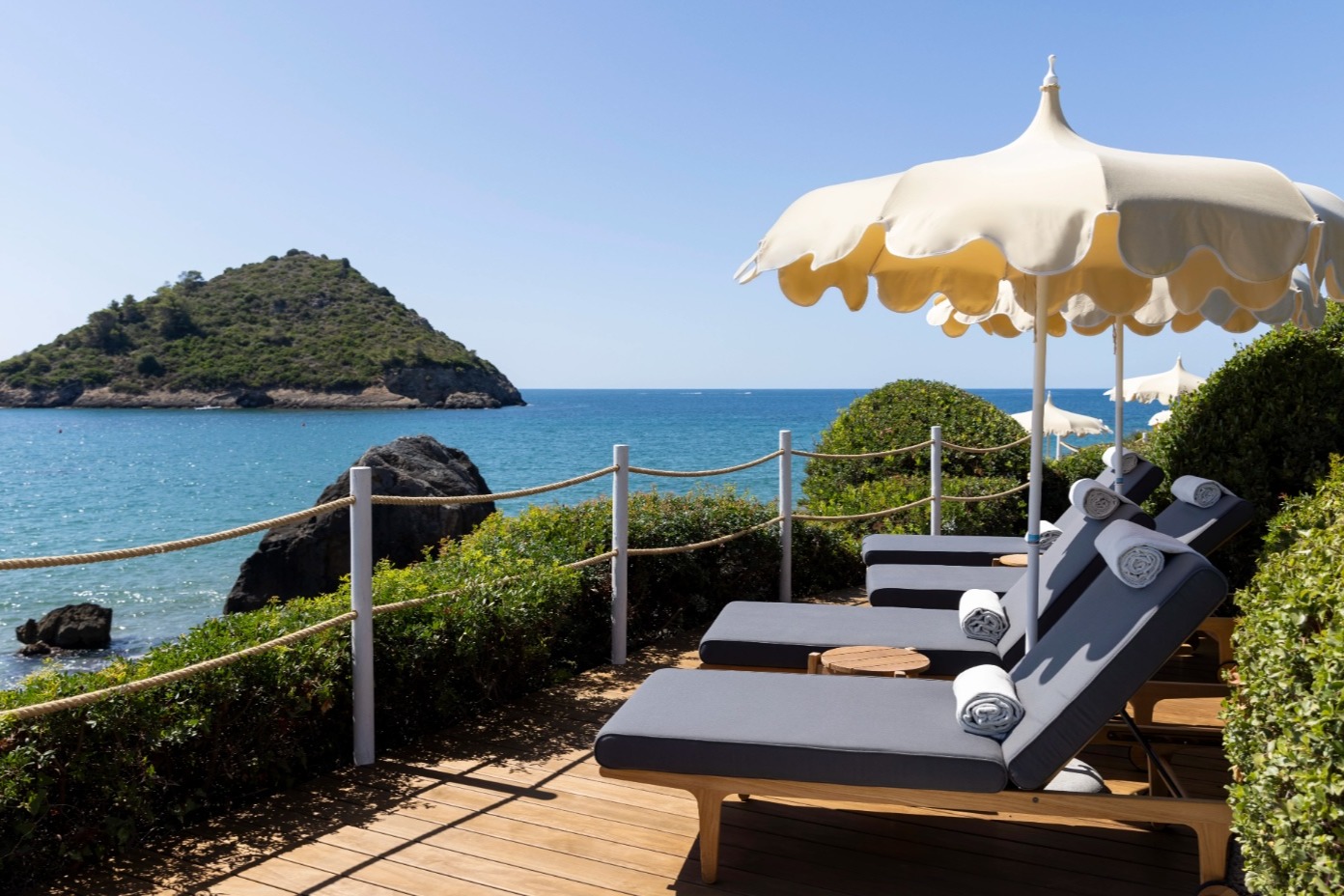 sun loungers on a patio with a view to the sea in Italy
