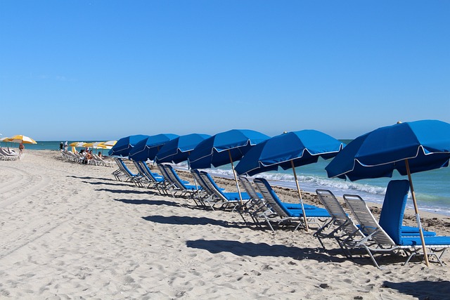 Blue umbrellas on the beach with loungers on a sunny day