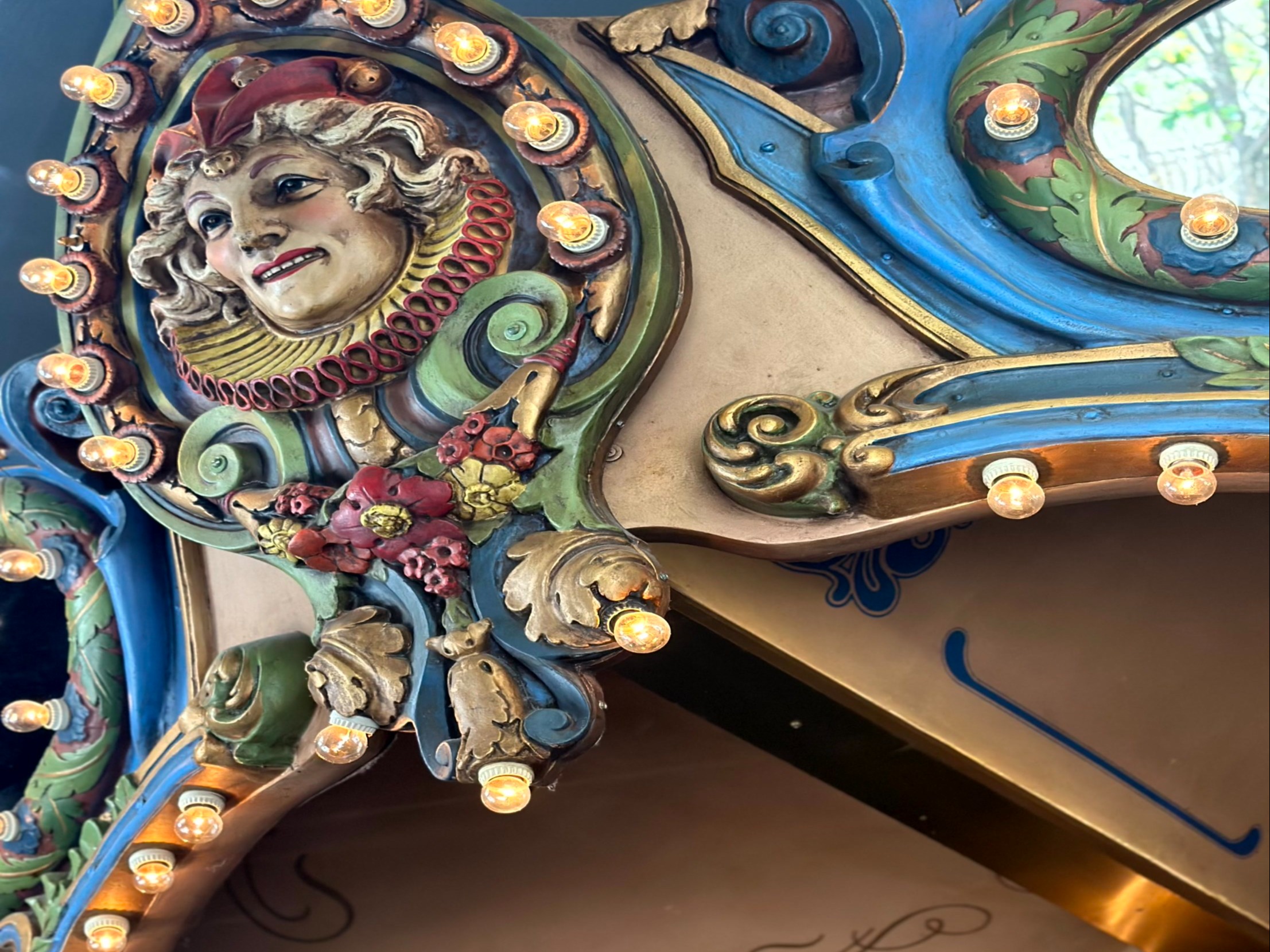 A detailed and ornate section of a carousel with decorative lights, exuding classic charm.