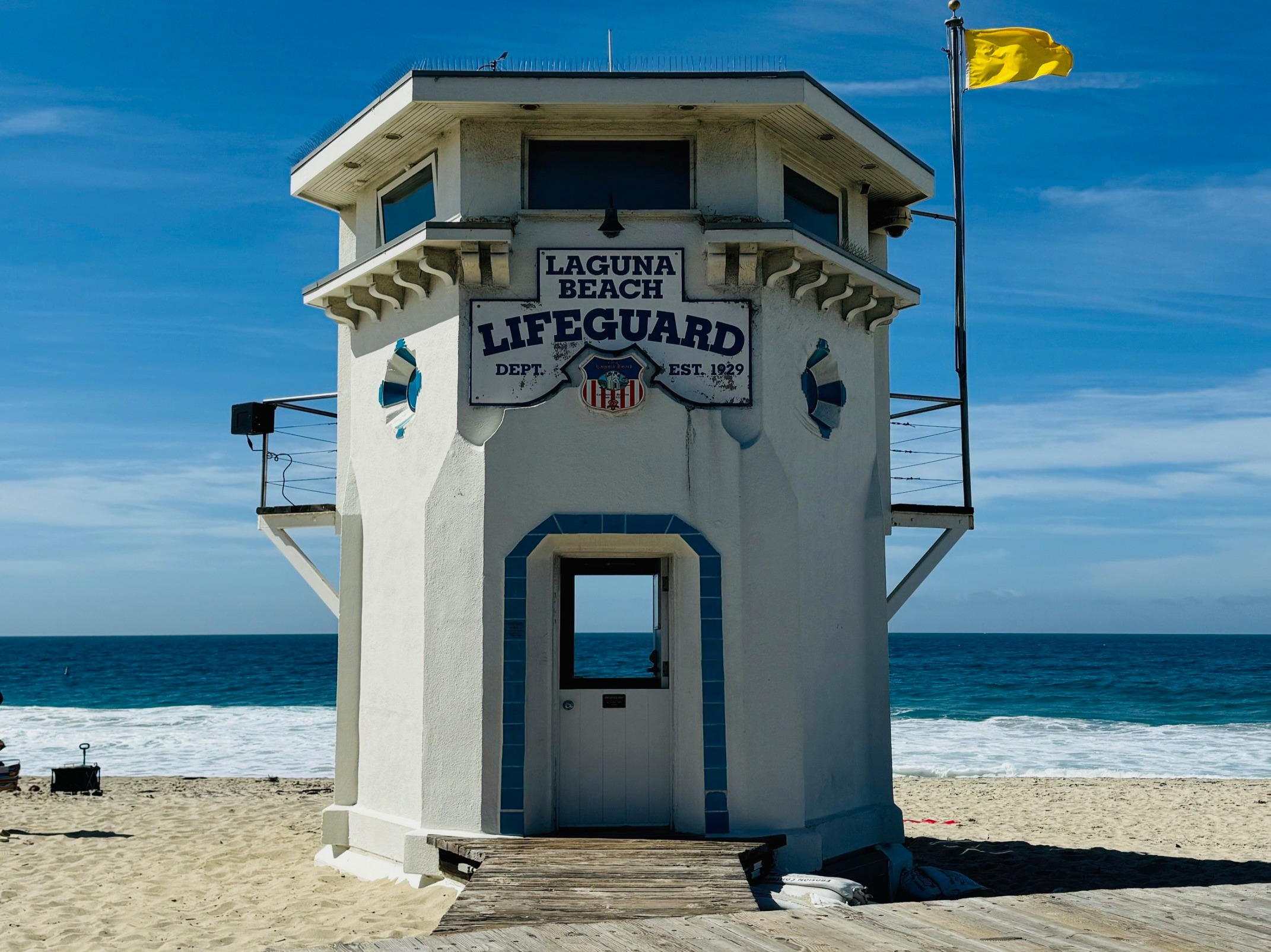 A serene Laguna Beach lifeguard tower stands against a clear blue sky.