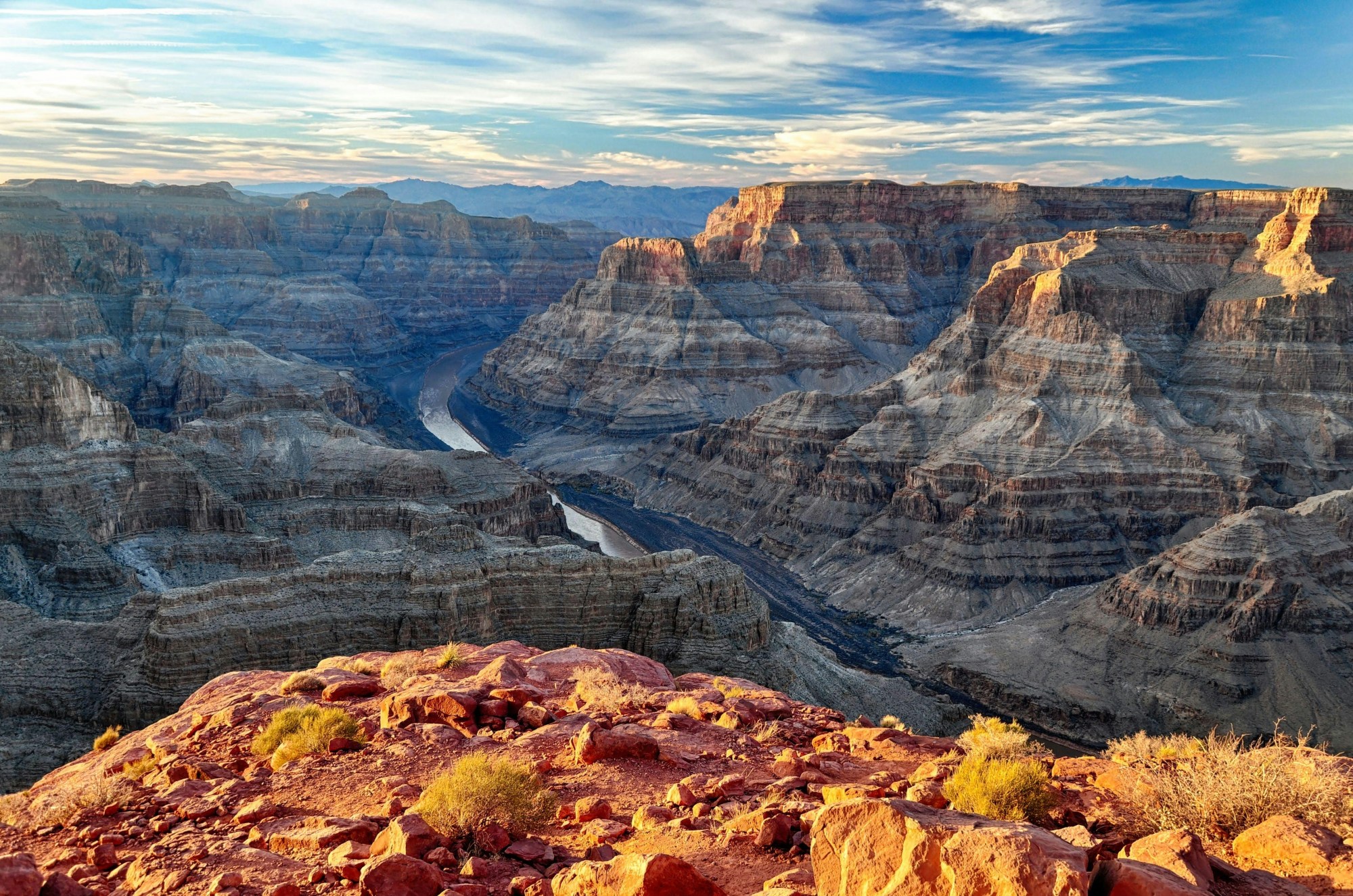 A view from atop the Grand Canyon down below, revealing its curves and colors on a sunny day.