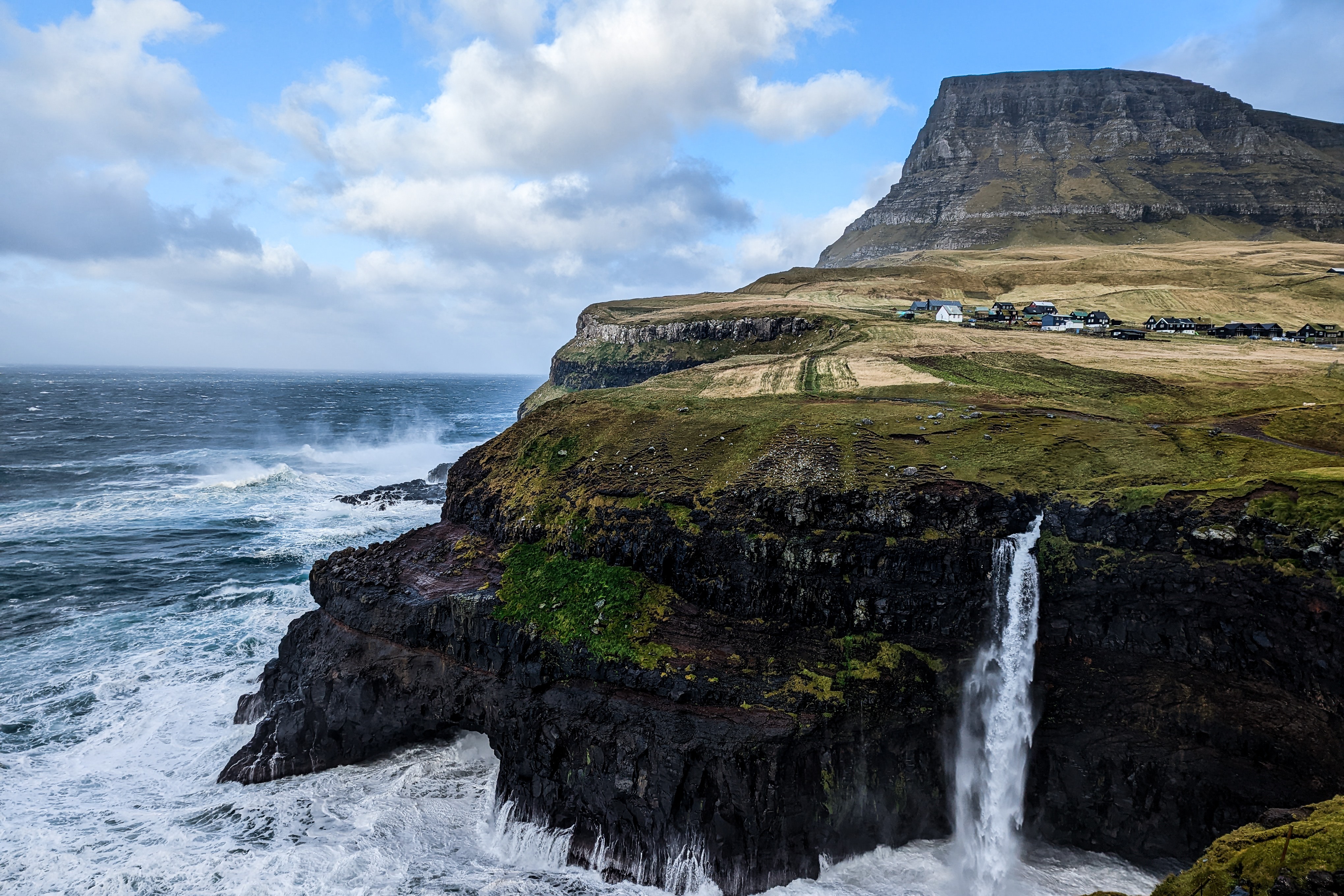 Waves crashing against a seaside cliff during the daytime