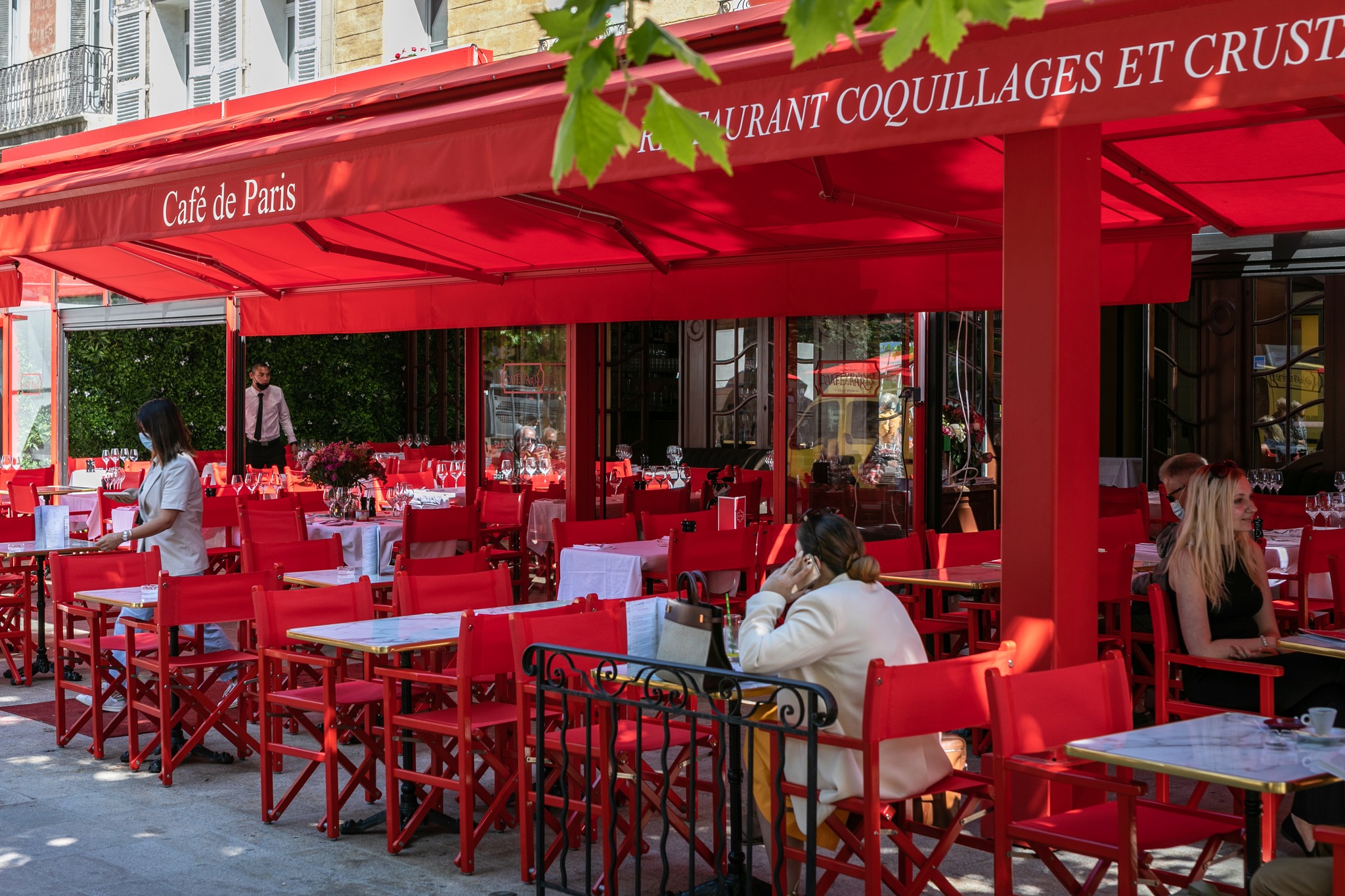 An all red outdoor seating era at a restaurant, with red chairs and a red awning over the tables