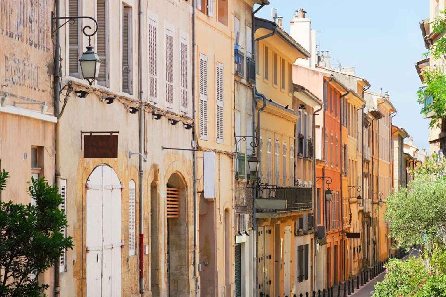 A row of orange and yellow buildings lined on a city street during the daytime