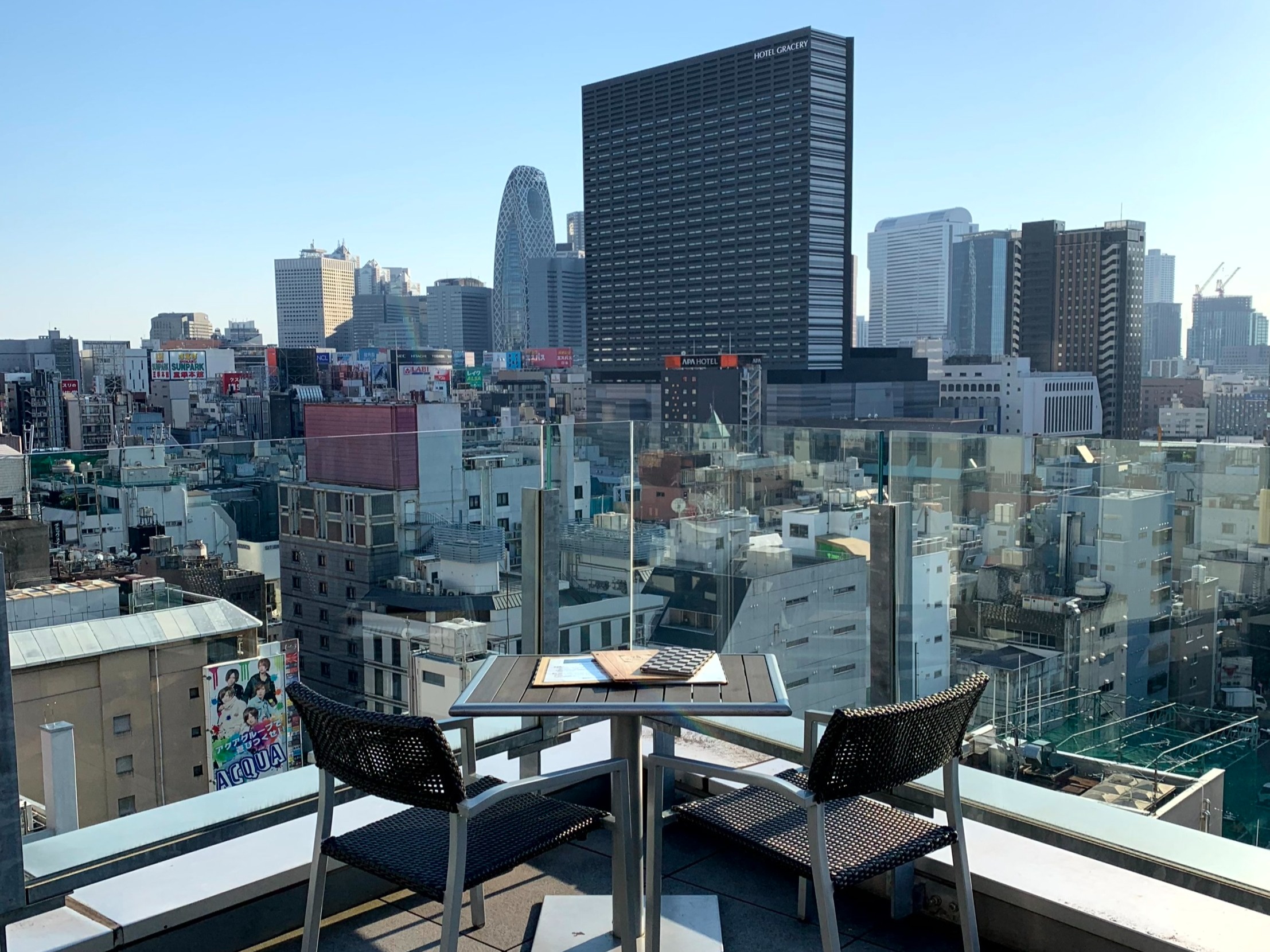 A panoramic view of a cityscape from an elevated perspective, showcasing diverse building structures under a clear sky.