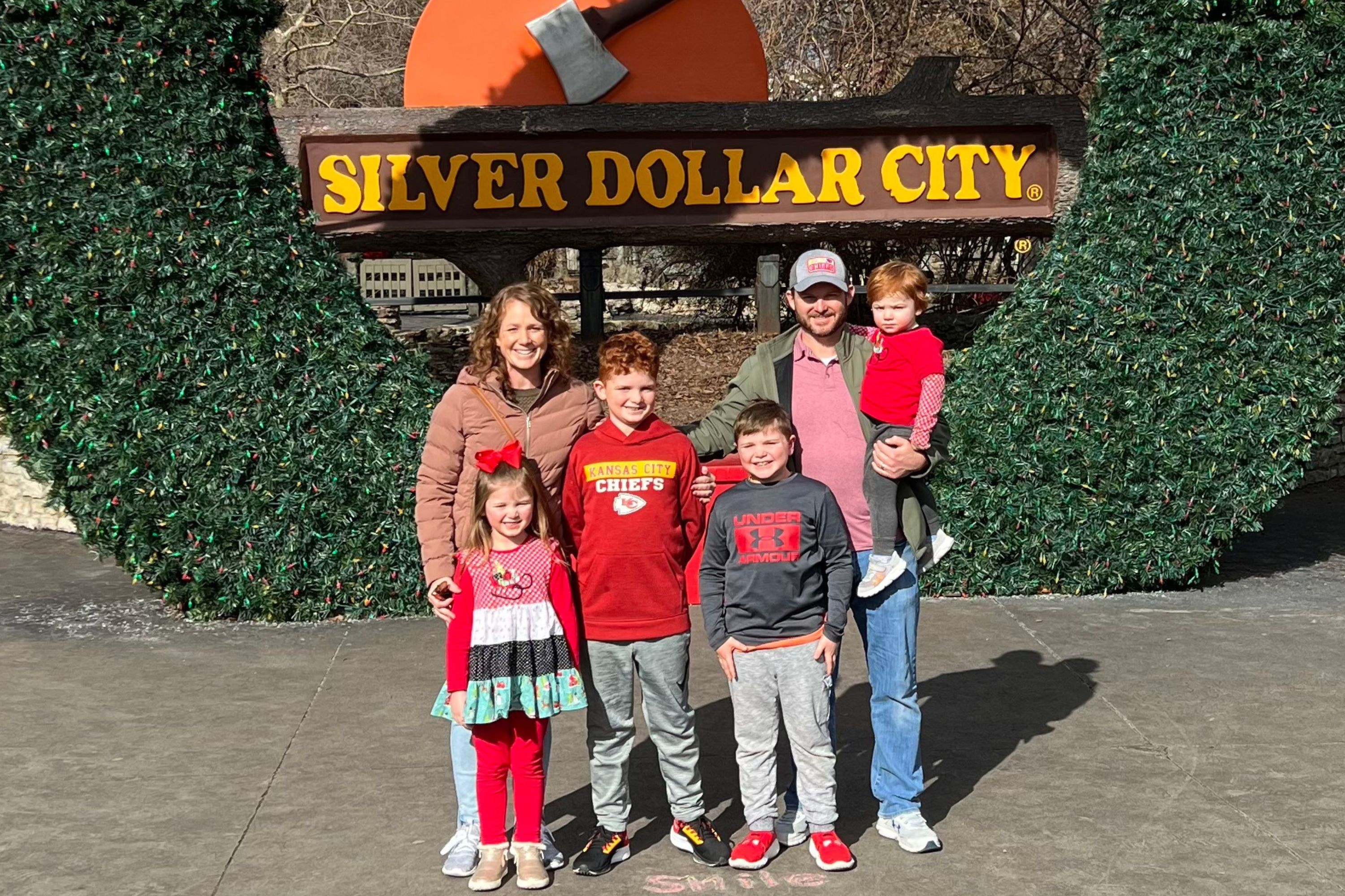 Family standing in front of Silver Dollar City signage