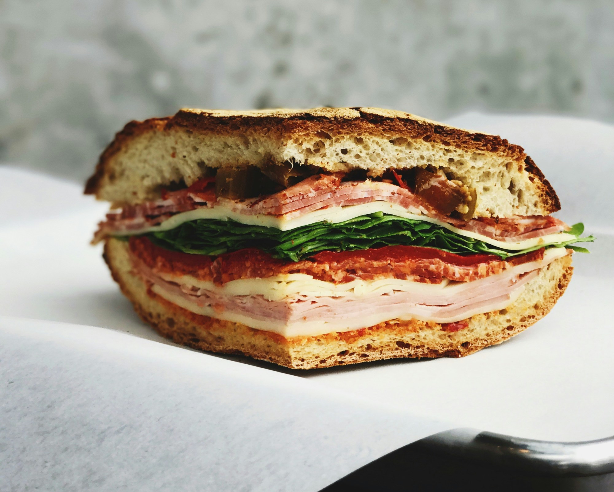 A large sandwich cut and placed on white parchment paper