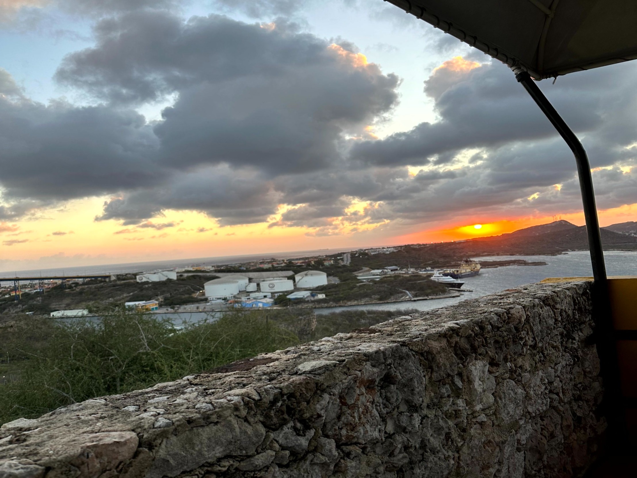 A stone wall overlooking the town during a sunset