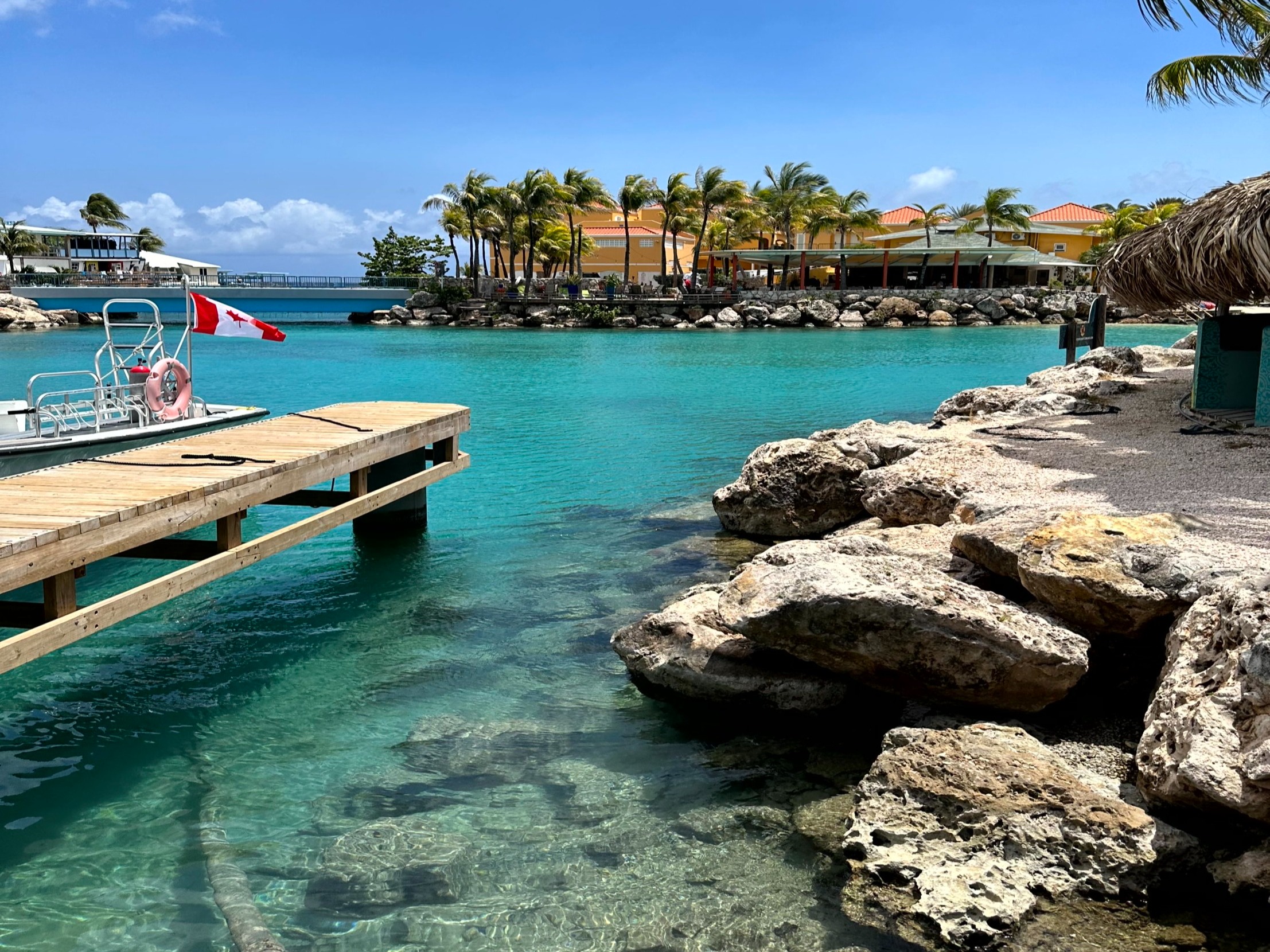 A wooden dock in the water next to large rocks