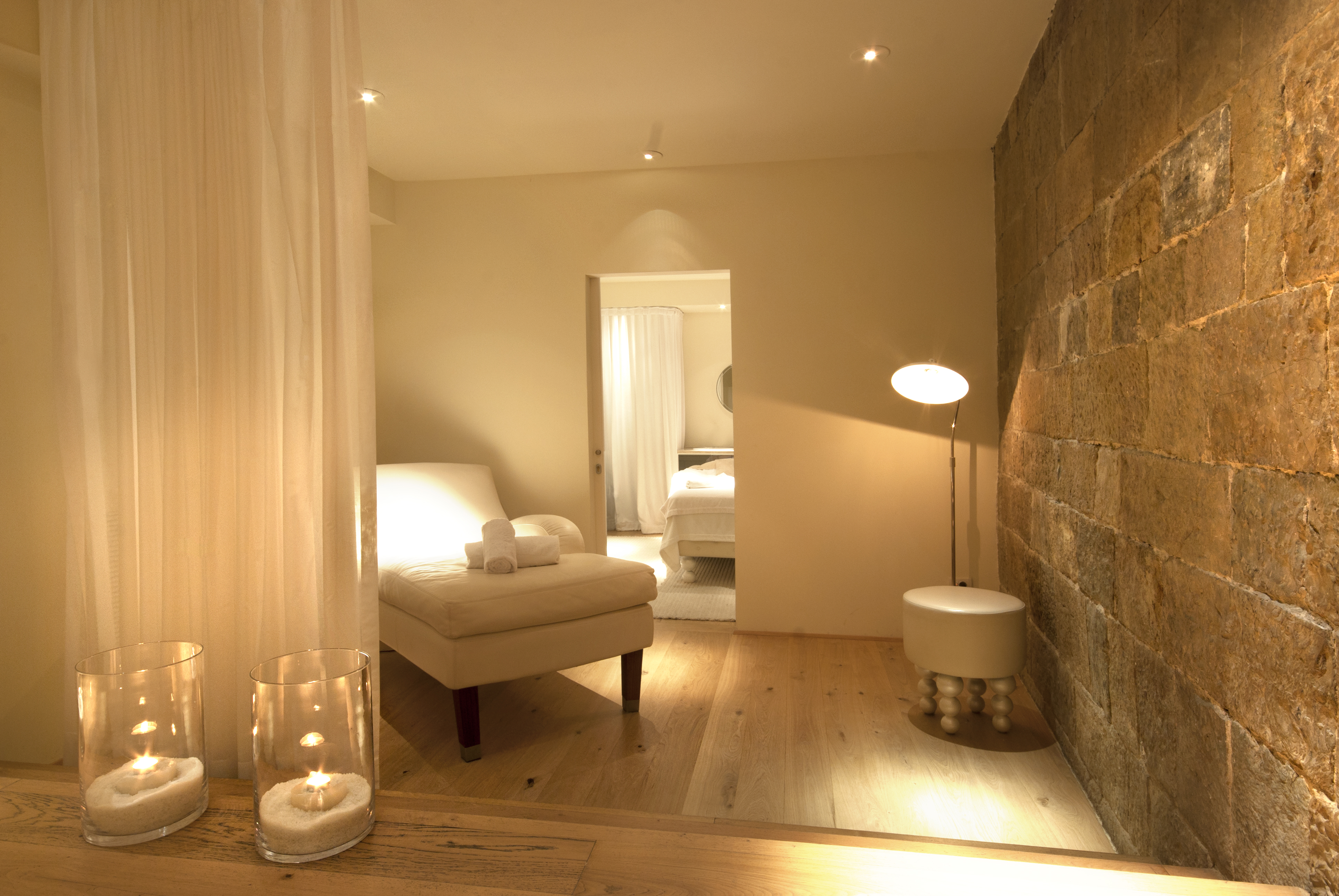 The image depicts a stylish lounge with circular seating, a central wooden table, and a striking circular light fixture, exuding a modern and inviting ambiance.