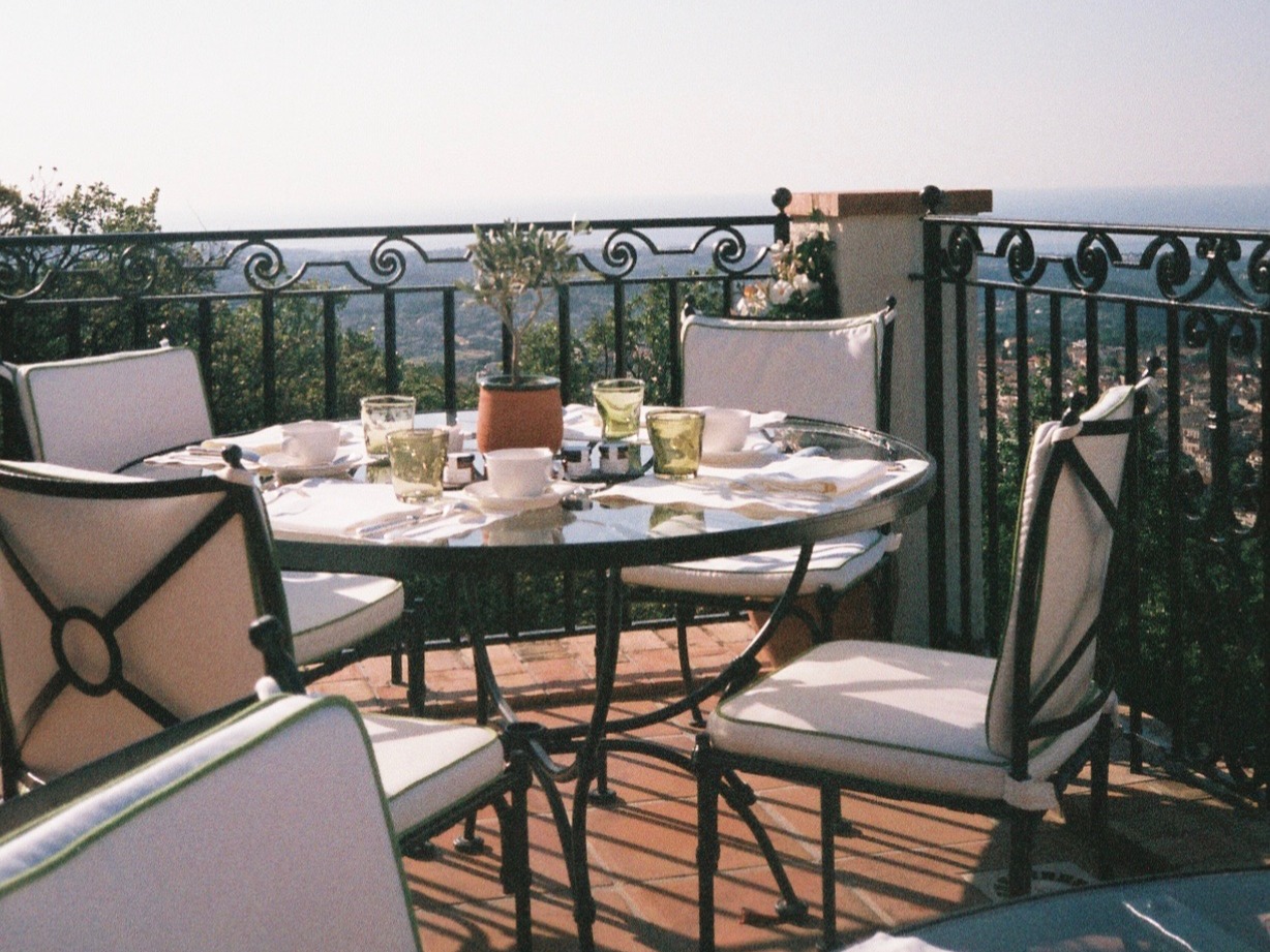Dining table, chair and food on a roof top terrace.