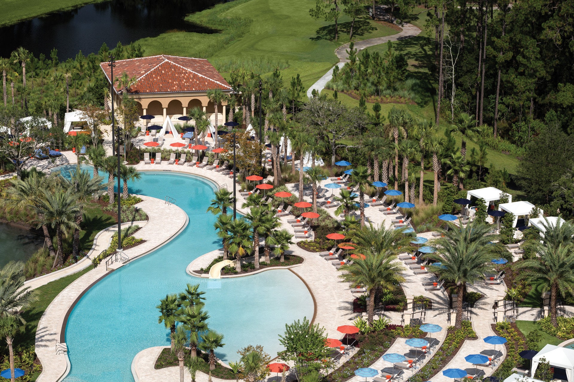 Dozens of loungers and palm trees surround a lazy river at Four Seasons Resort Orlando