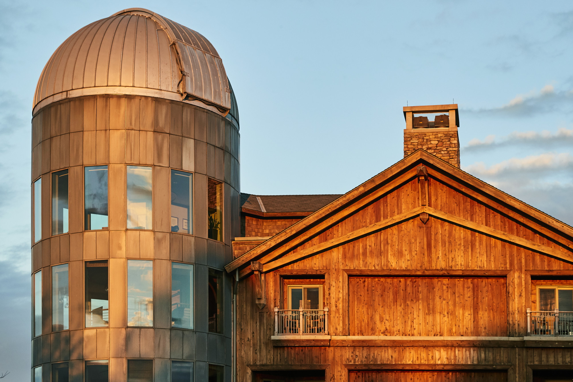a wooden barn near a dome-roofed silo on a sunny day