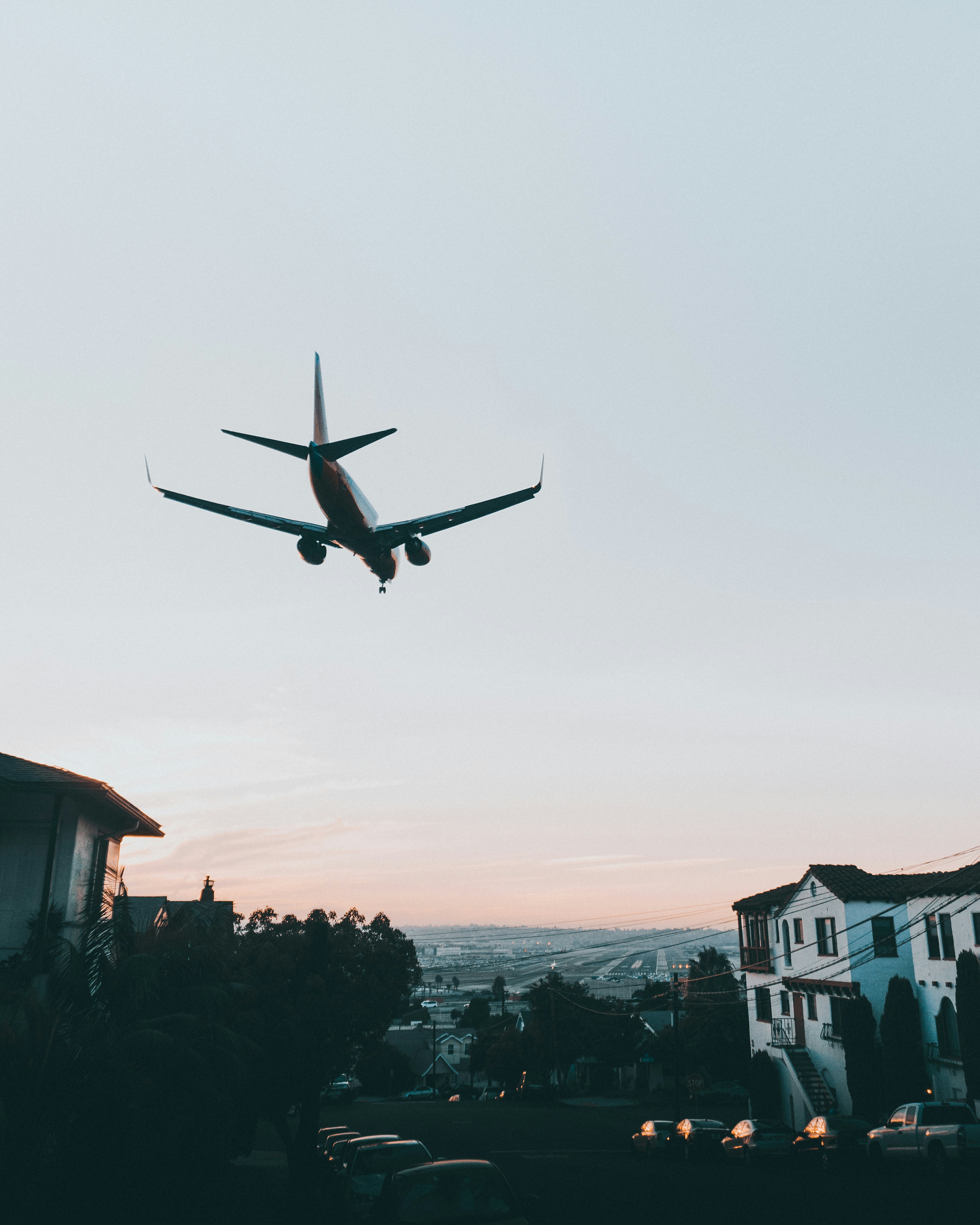A plane that just took off and is flying over a residential San Diego neighborhood.