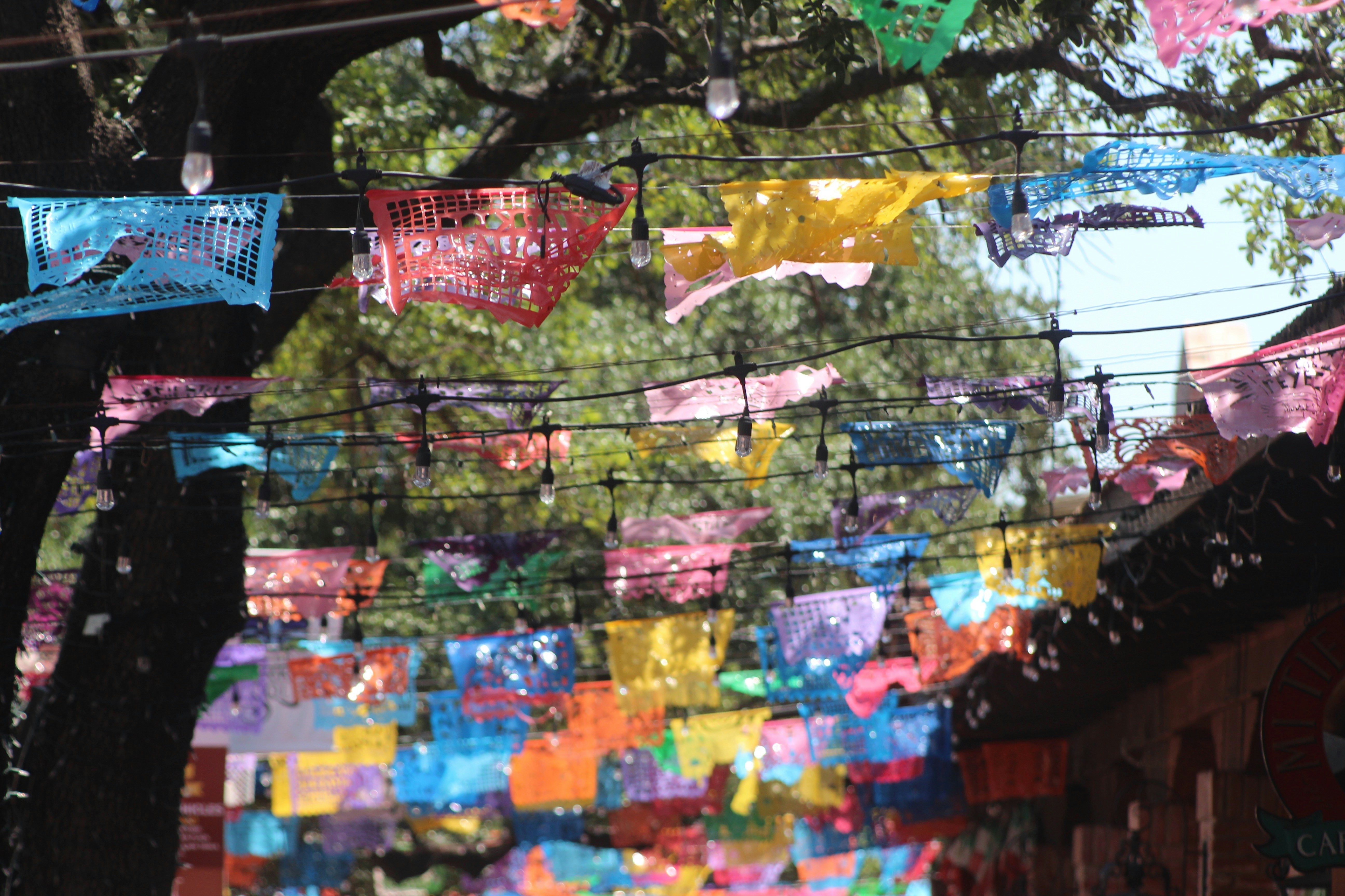 A scene of rows of colorful and festive Papel Picados outside of the Mi Tierra Café in San Antonio, Texas.