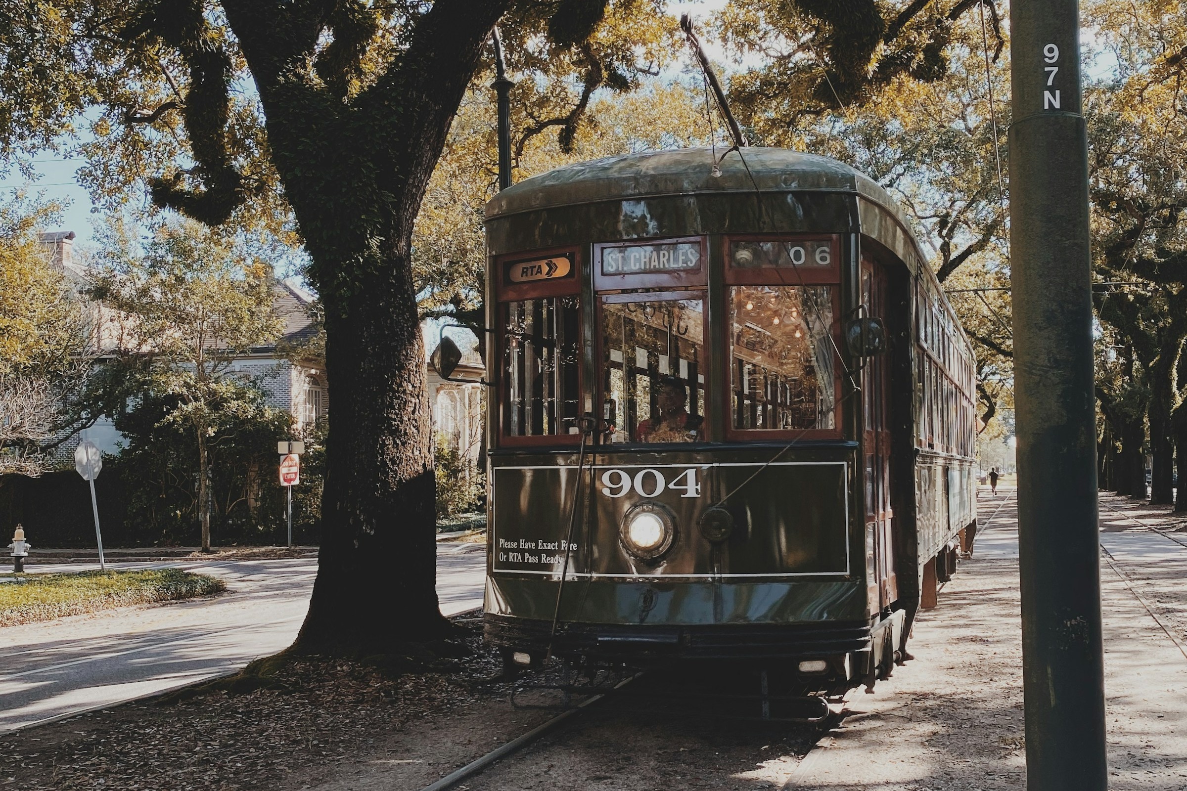 A street car in between trees during the daytime