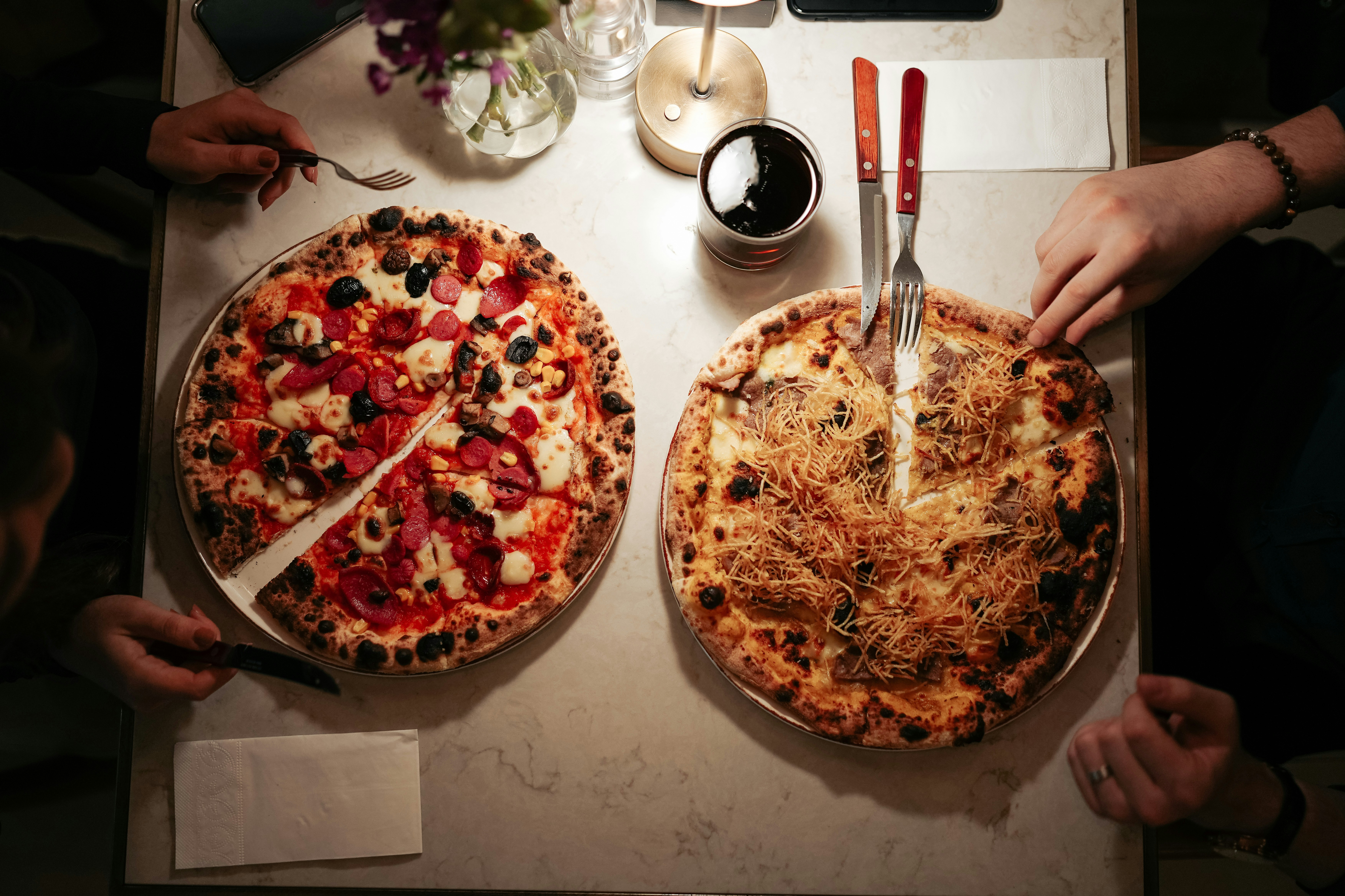 A picture of a table at a restaurant with pizza served on it.