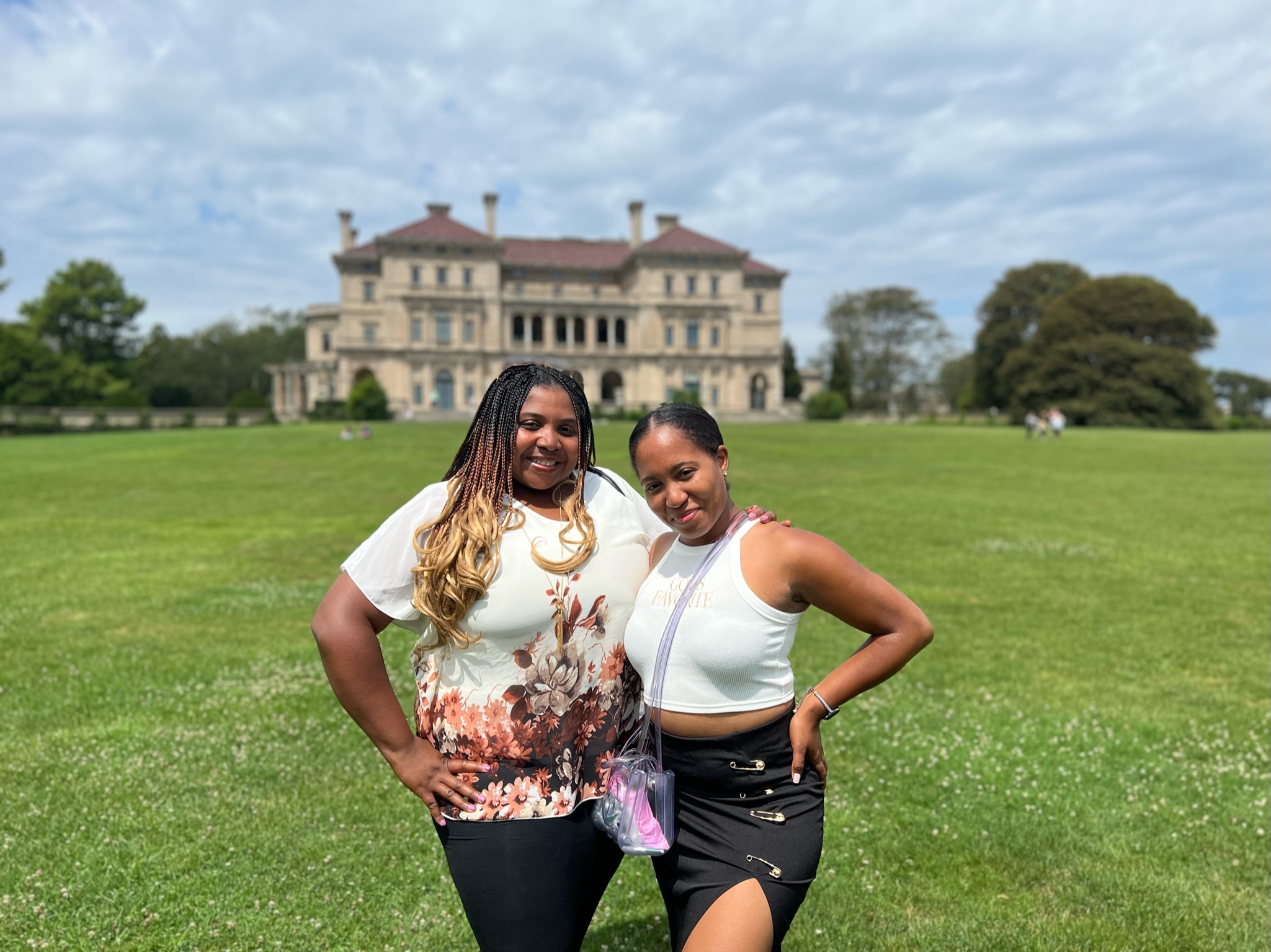 Two women posing on a grand lawn in front of one of Rhode Island's mansions.