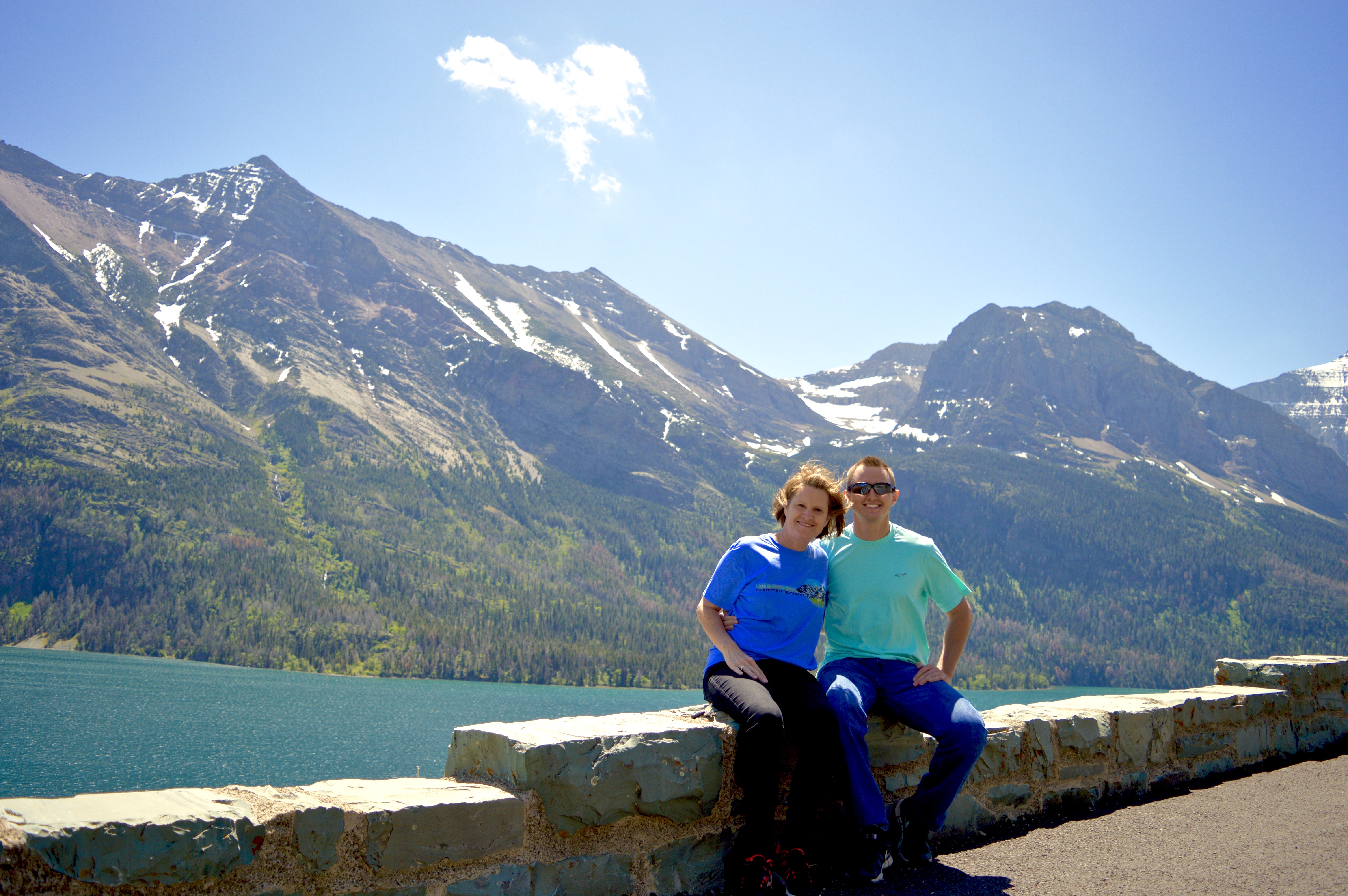 A couple posing for a photo in front of a mountain during the daytime