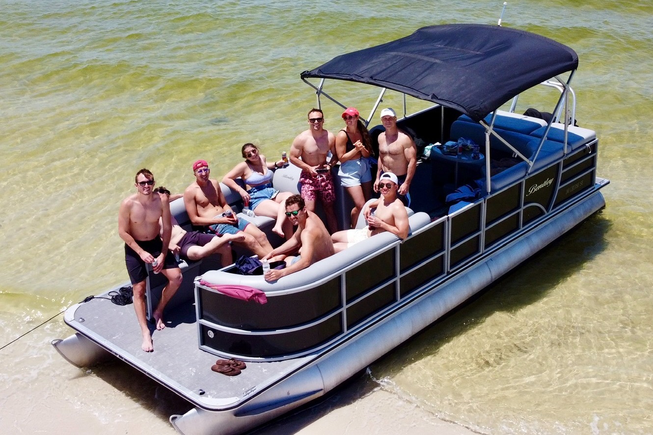 A group of people on a pontoon boat in the water