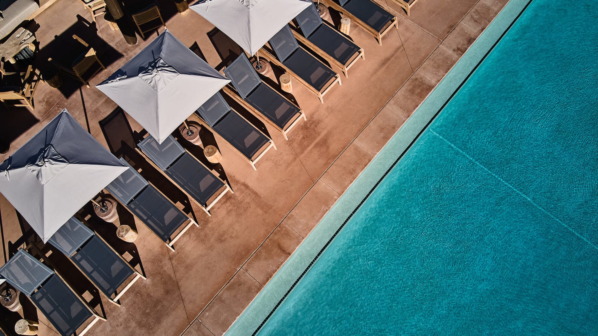 A row of sun loungers next to a pool