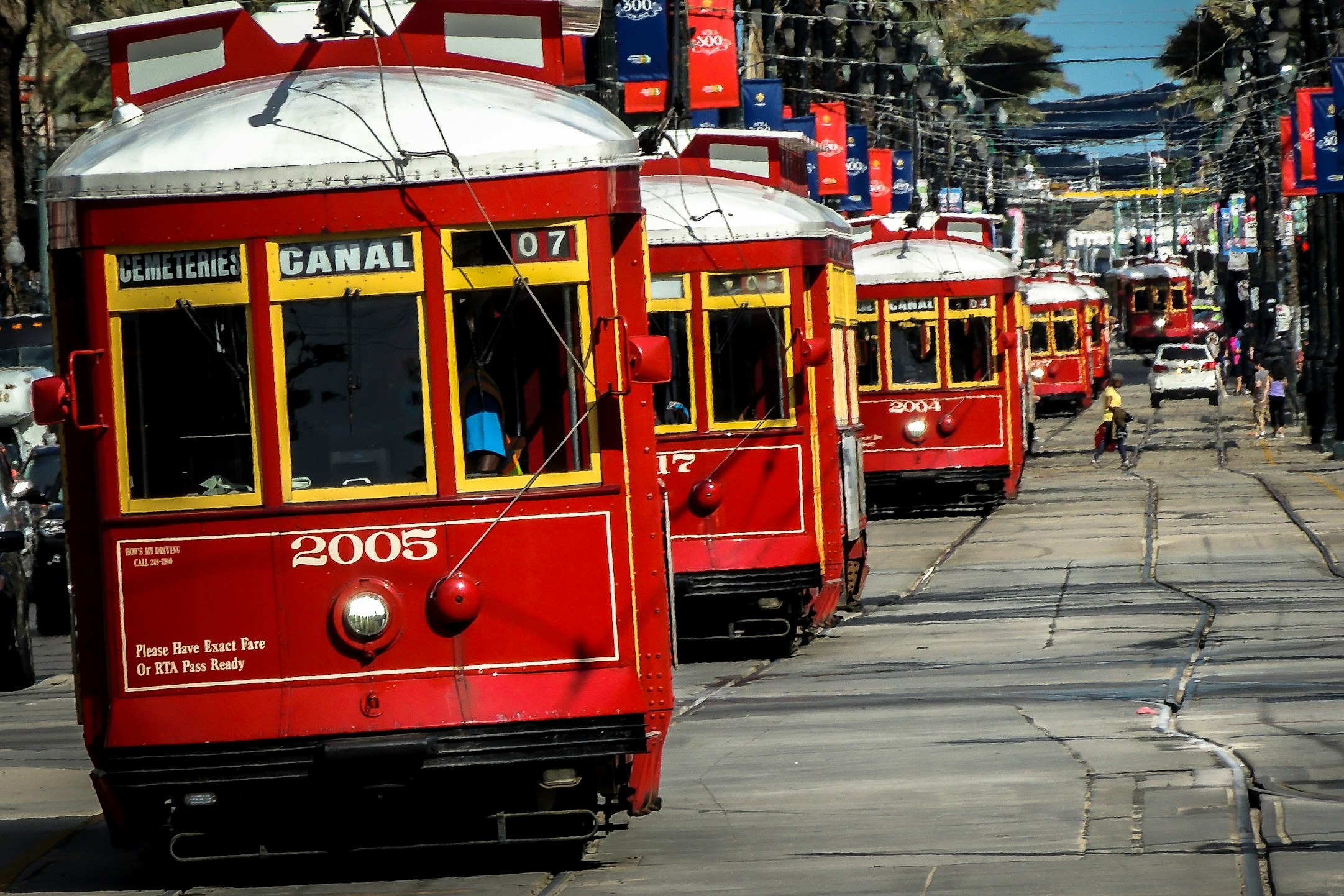 A row of red trolley cars waiting to take you to French Market.