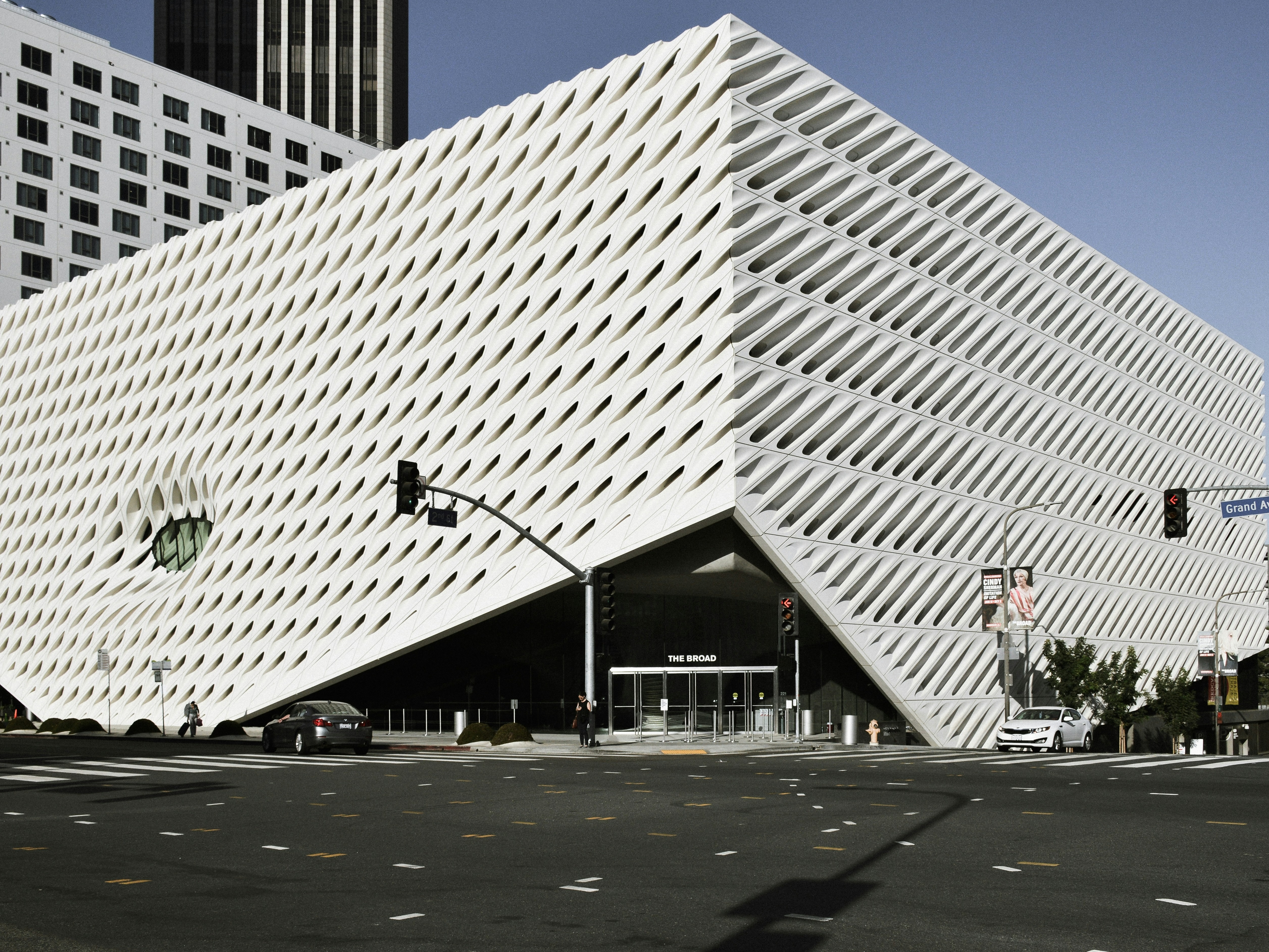 A picture of a white-colored building in a triangular shape taken during daytime.