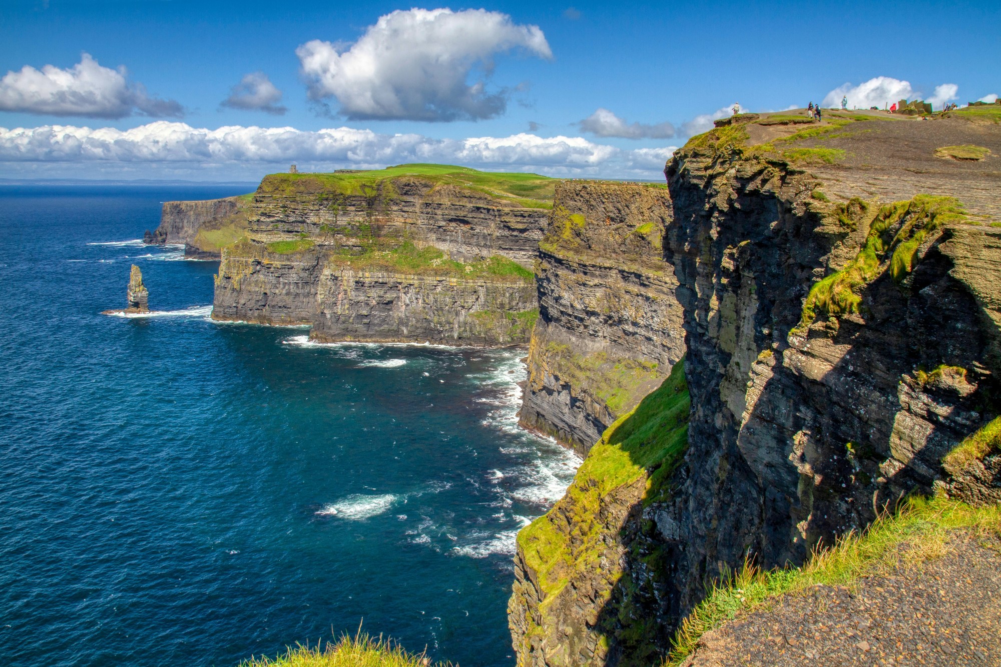 A view of green rocky cliffs near a blue ocean.