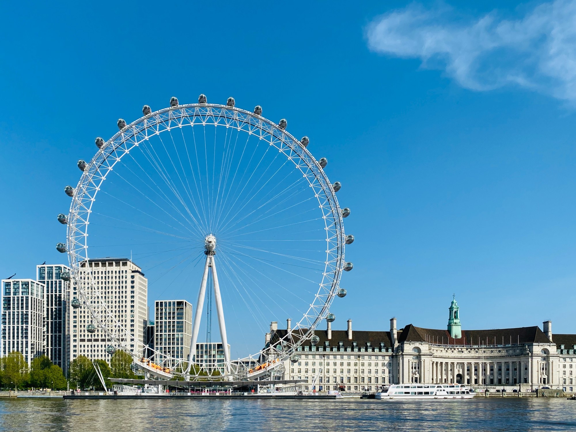 The London eye, a large ferris wheel by the River Thames on a sunny day