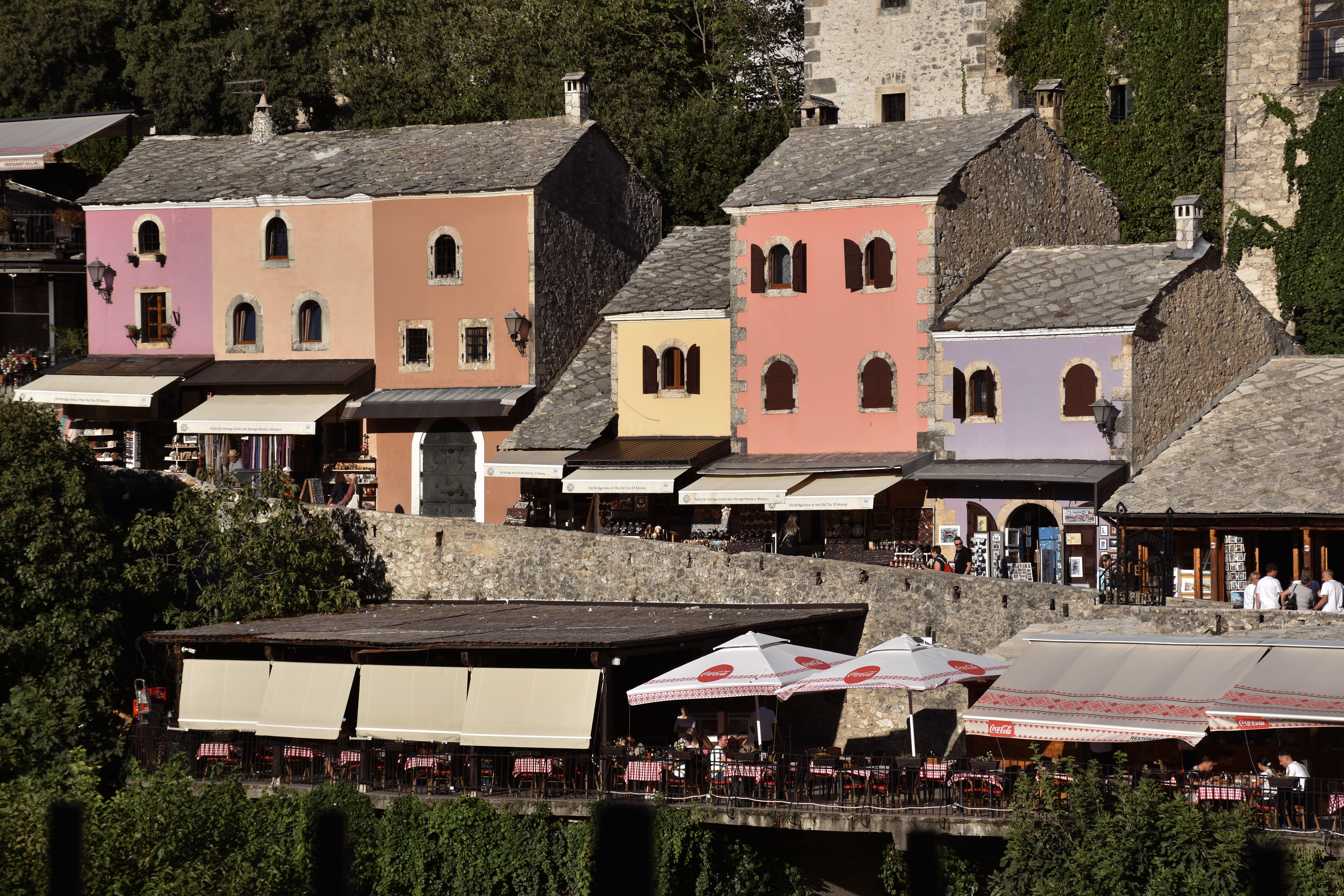 Colorful houses on a hillside above a restaurant patio.