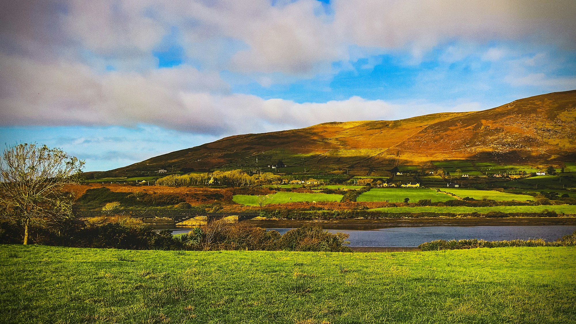 River flowing in front of green hills.