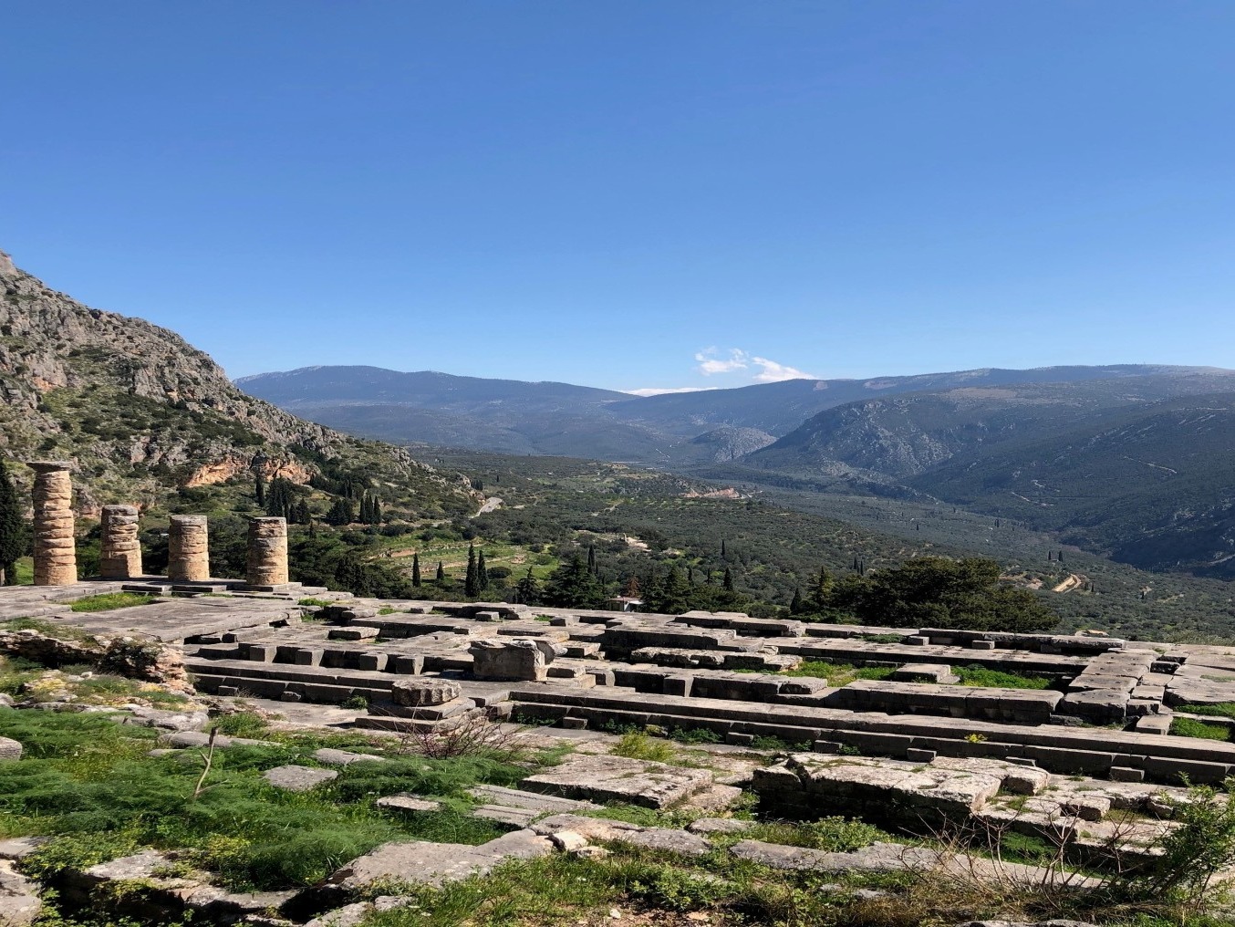 A picture of ruins near green mountains taken during the daytime.