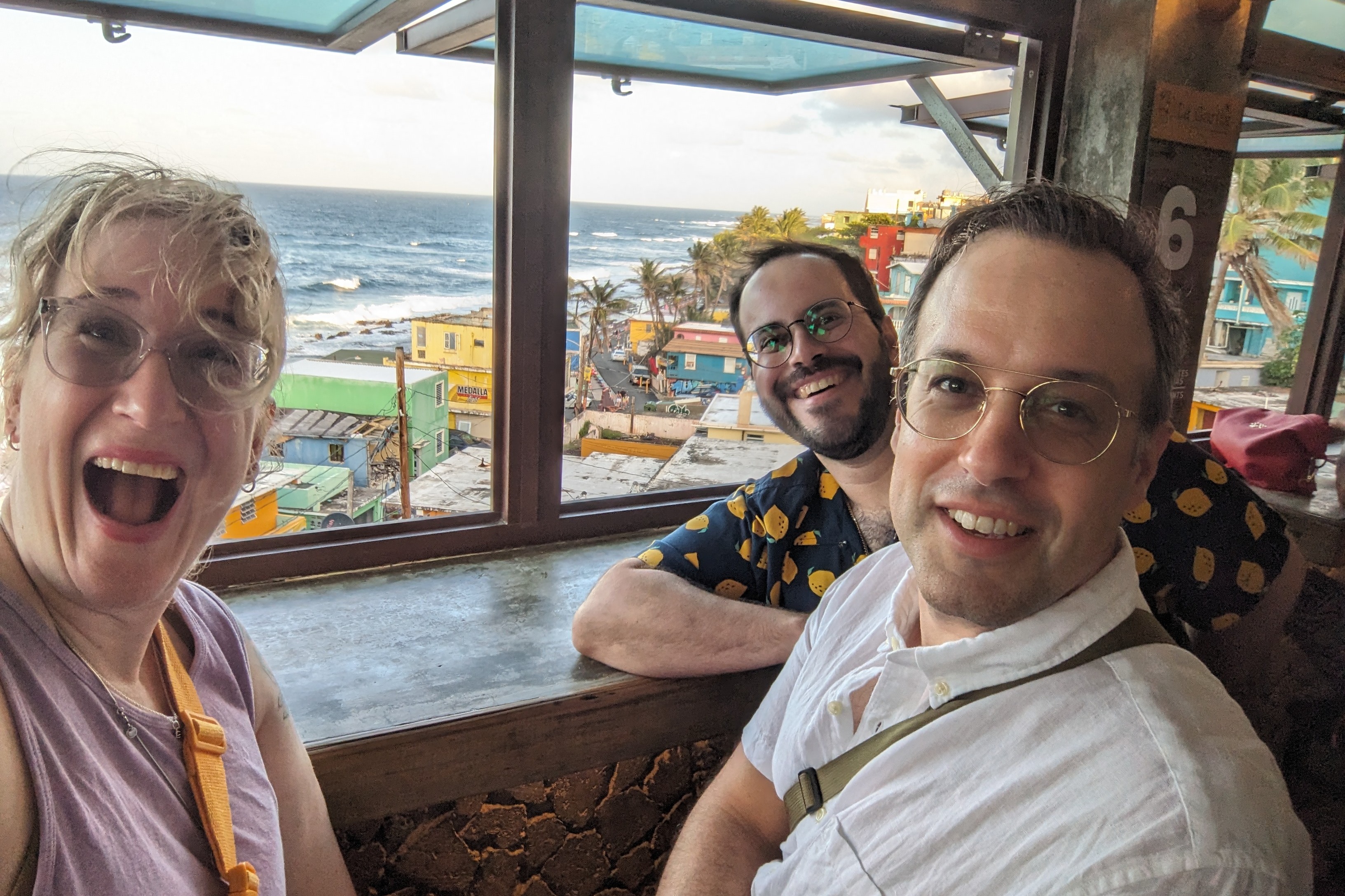 A picture of people looking into the camera and smiling near the sea view.