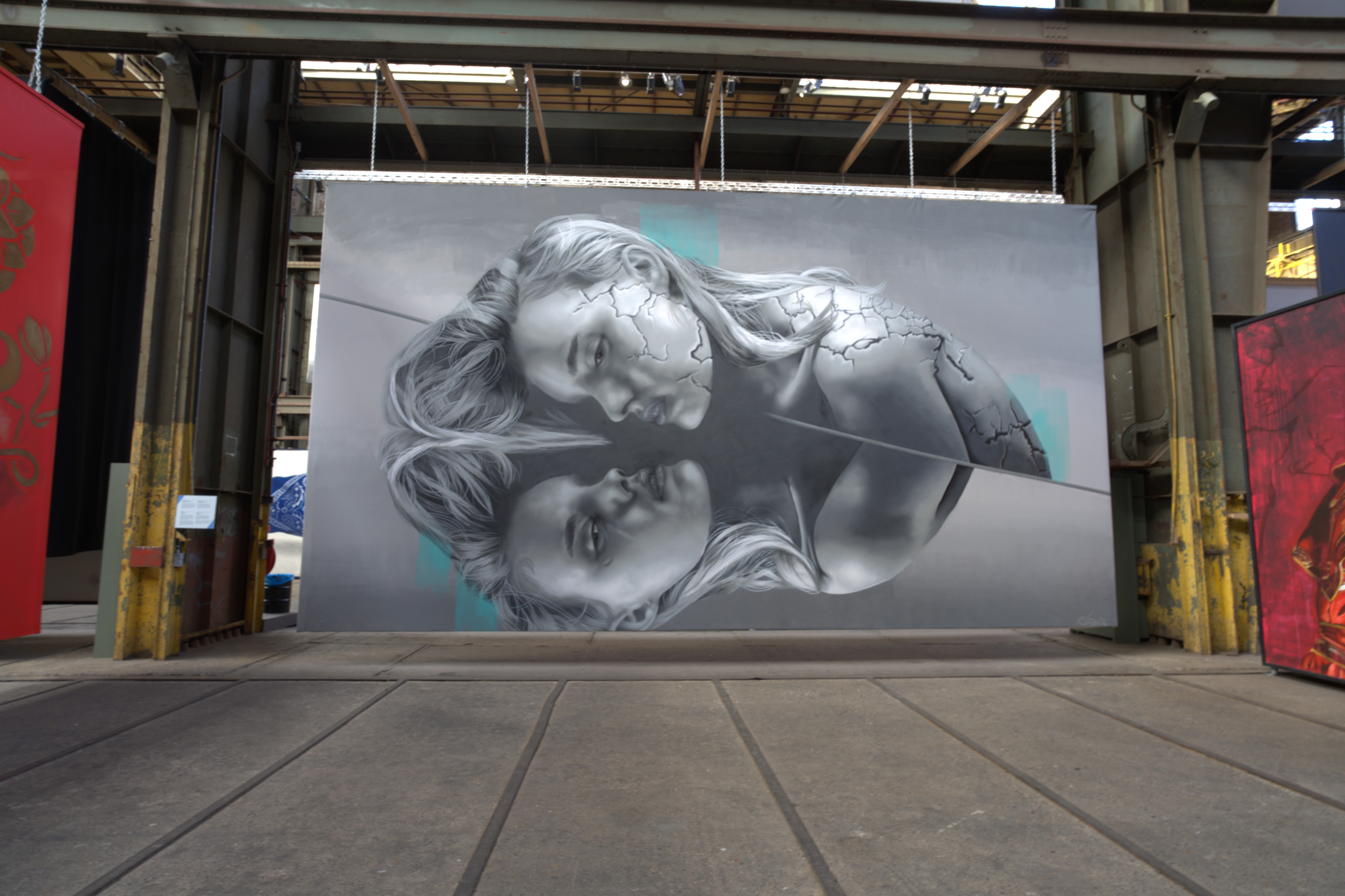 A black and white piece of artwork hanging in a warehouse