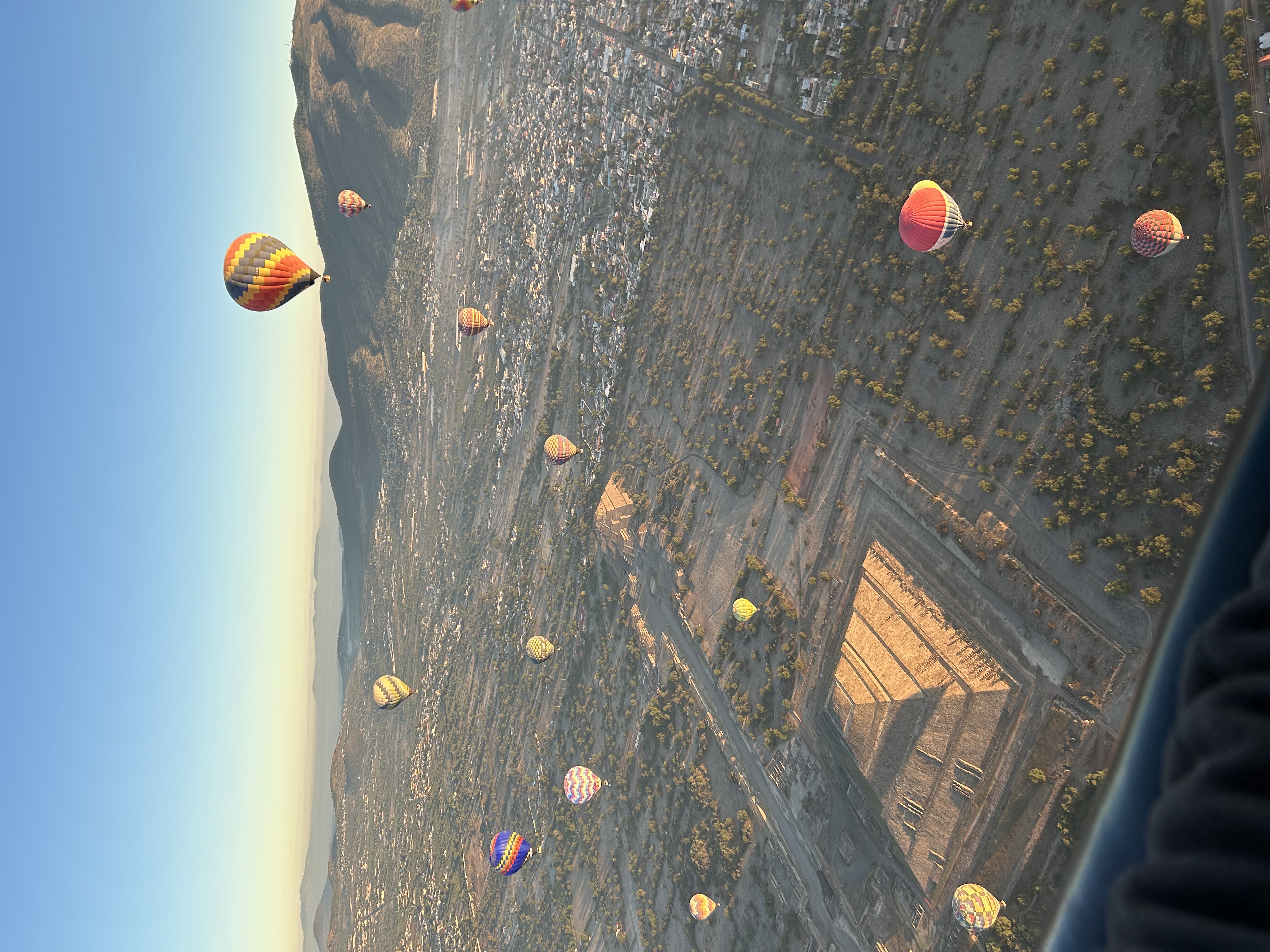 Aerial view of hot air balloons flying over pyramid