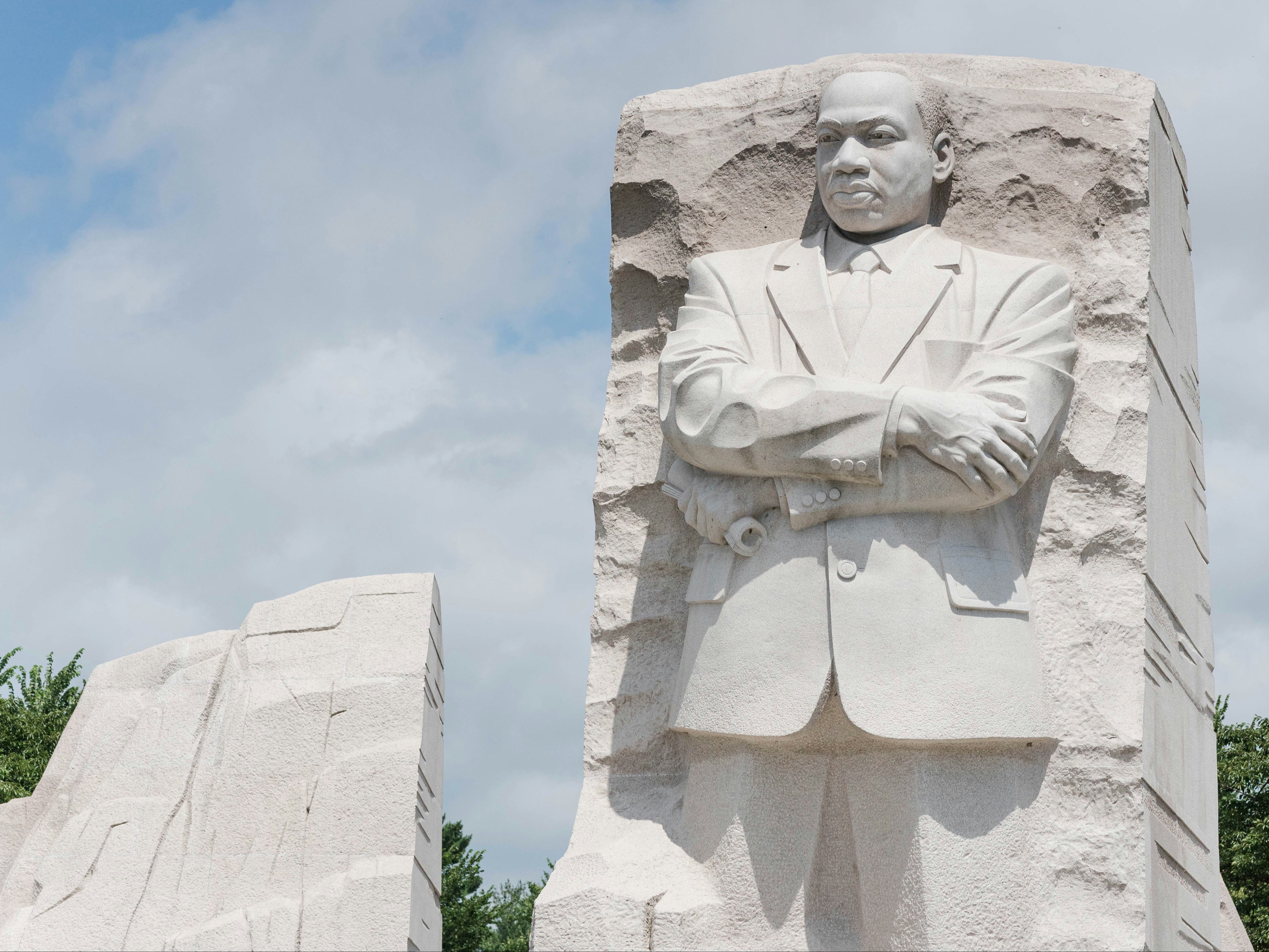 A white colored statue of Martin Luther King, Jr., during the daytime.