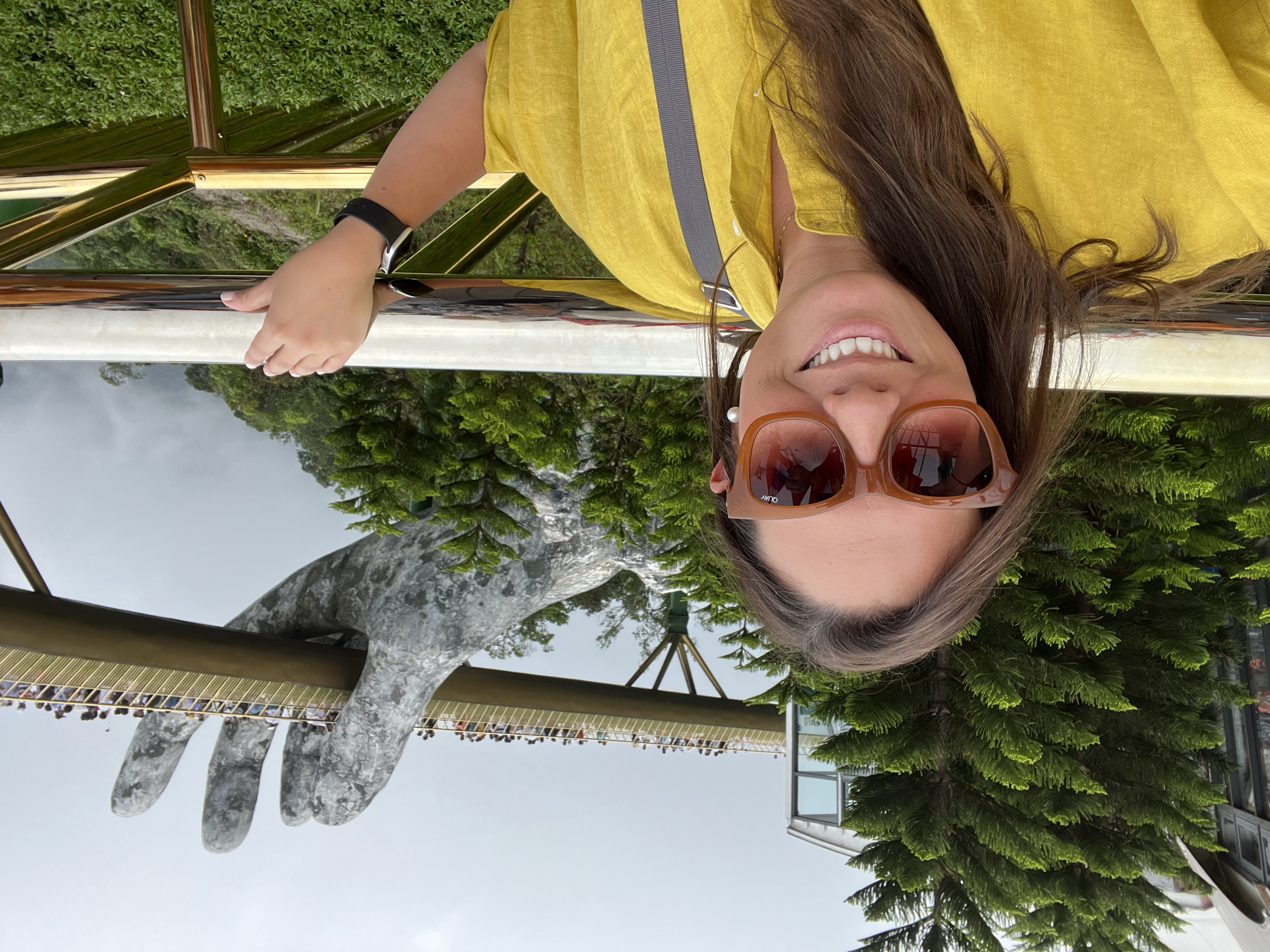 Travel advisor Andrea in a yellow shirt and sunglasses standing in front of the Golden Bridge Vietnam