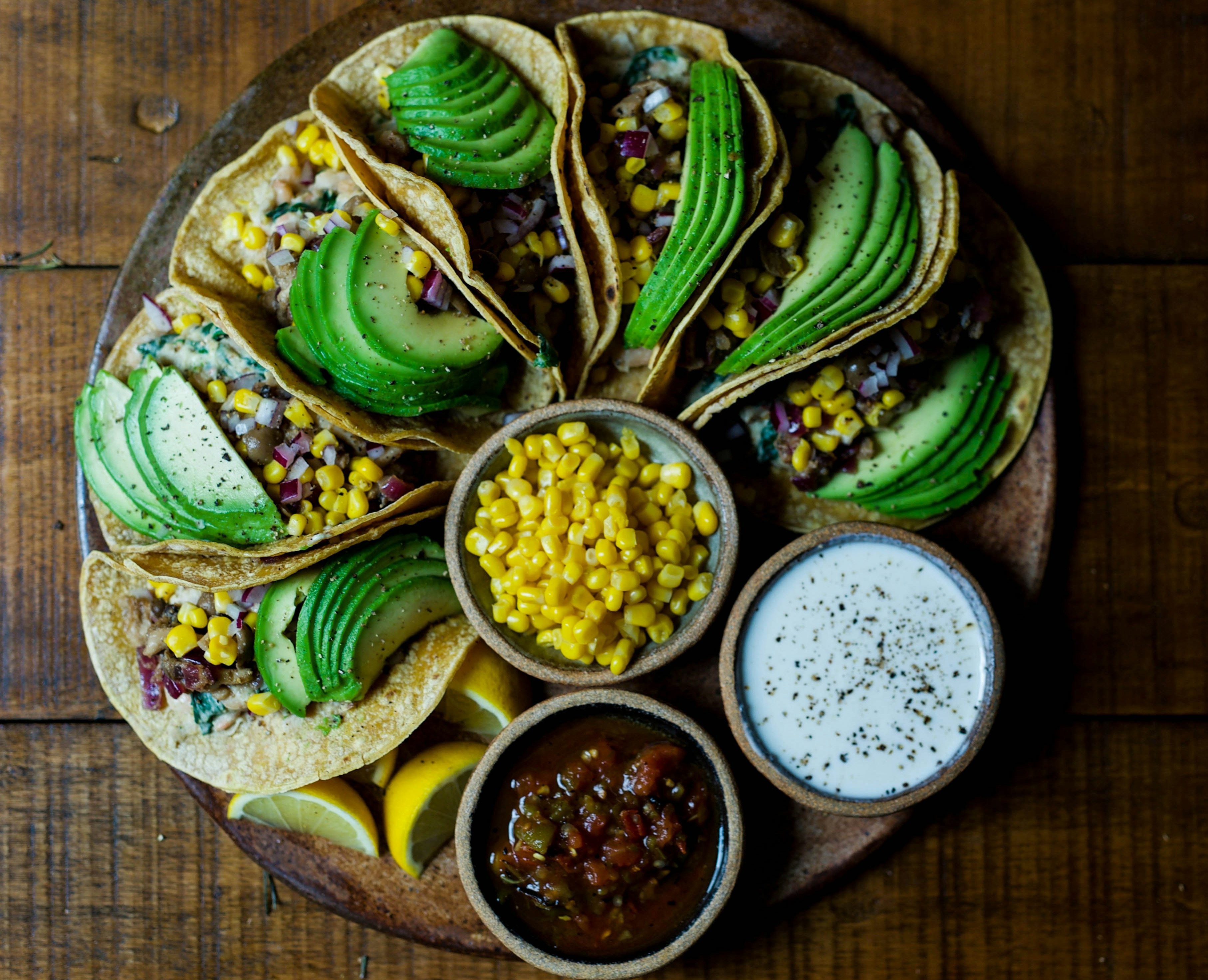 Tacos on a plate with avocado and salsa