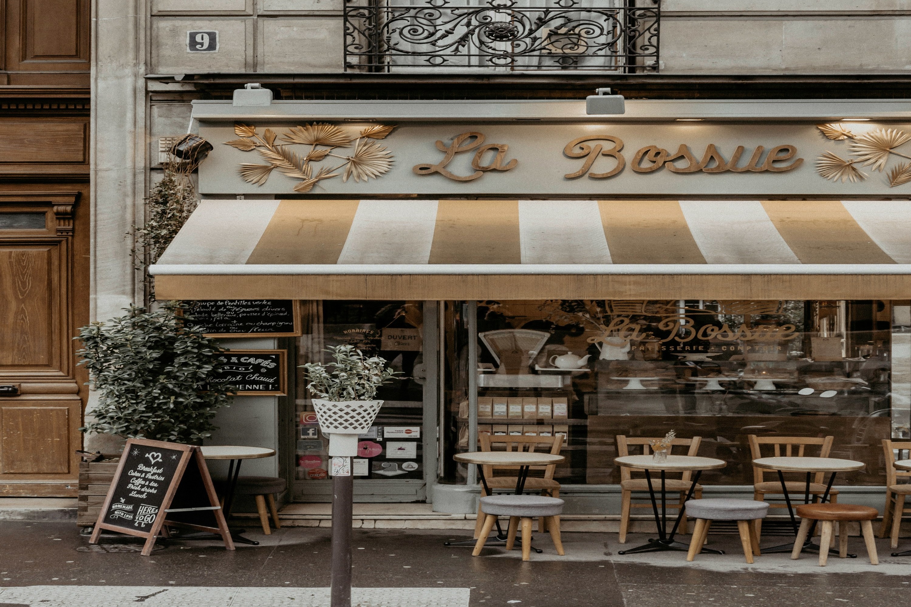A picture of a brown wooden table and chairs outside a cafe.