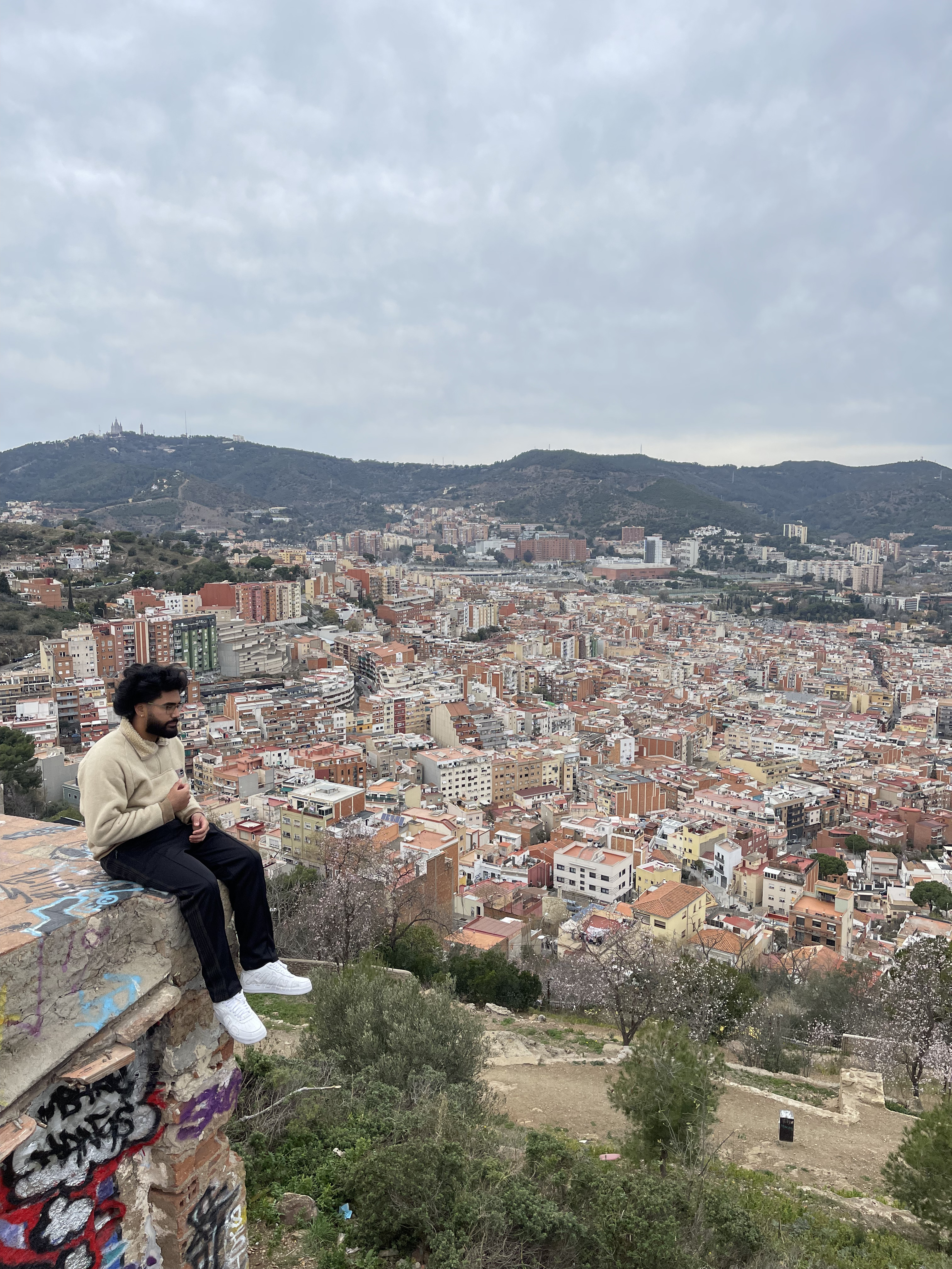 ravel advisor Matthew sitting on the edge of a high wall overlooking a large city