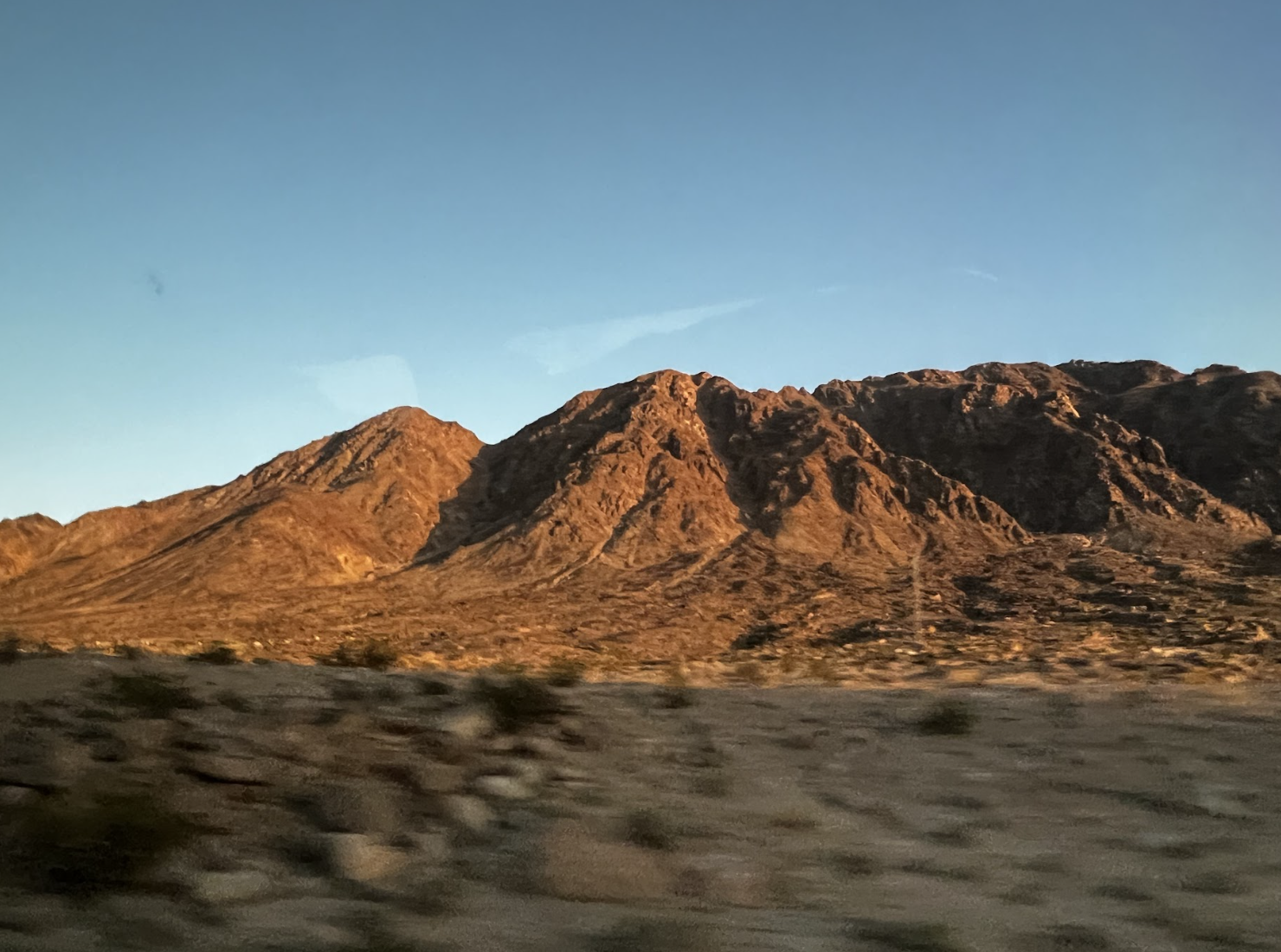 A view of a desert mountain under a blue sky.