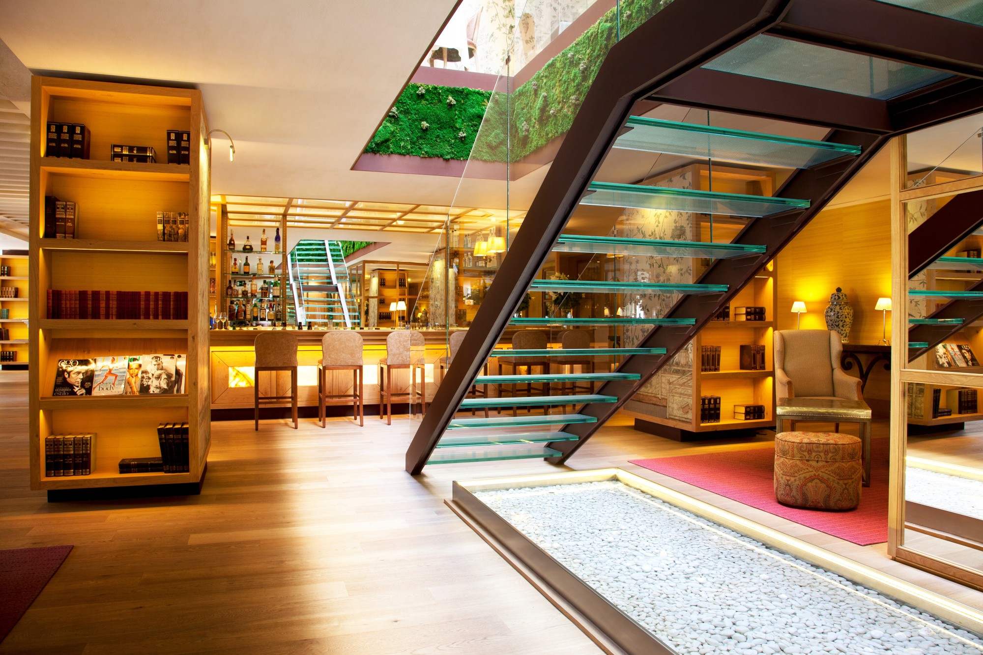 a floating glass staircase in a handsome bar