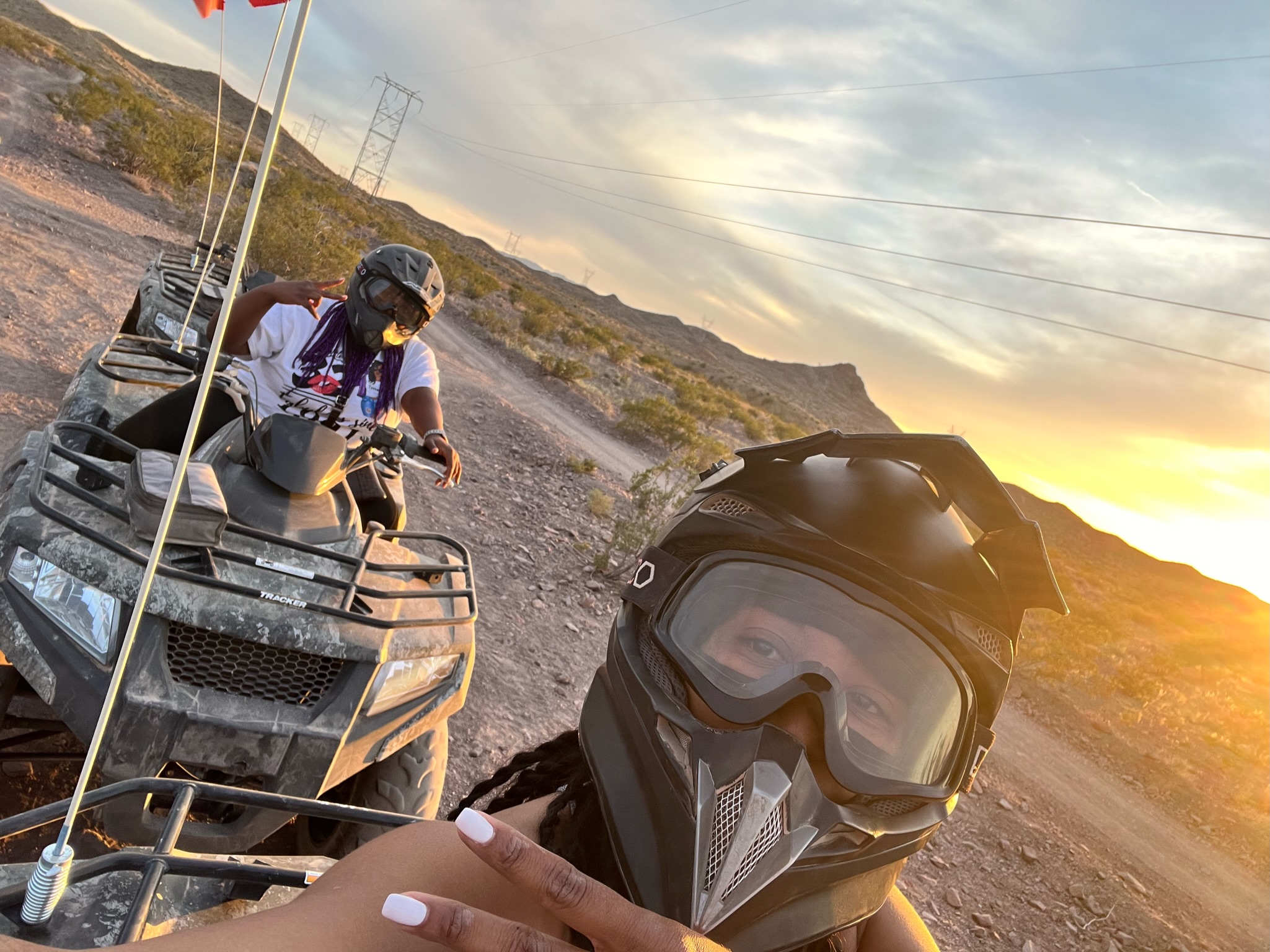 A picture of people riding a quad bike in the desert during the daytime.