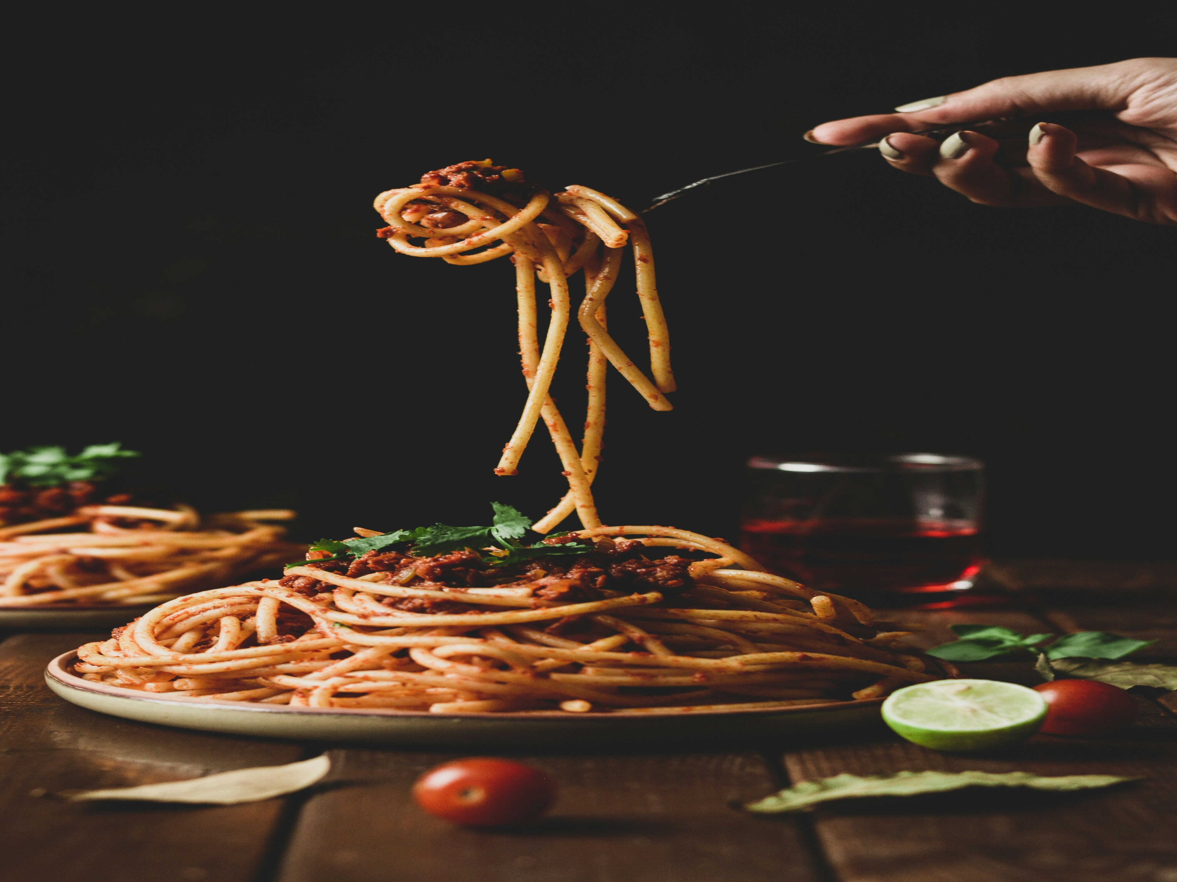 A picture of a person holding a pasta with a fork.