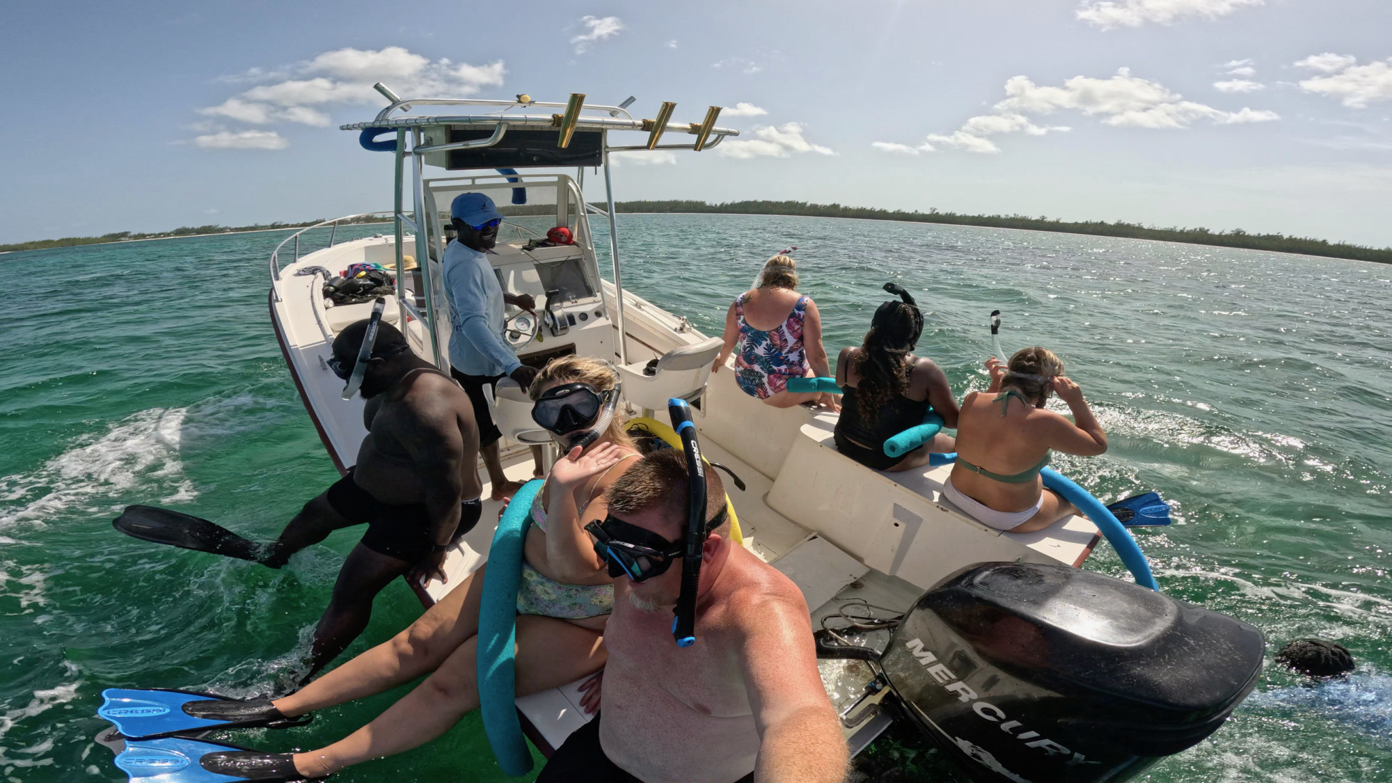 People on small boat in snorkeling gear.