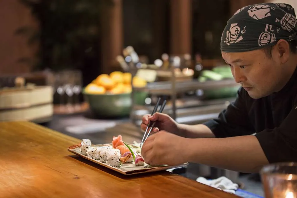 A sushi chef carefully plates sashimi at Nama, the Japanese restaurant at Amanjena in Marrakech