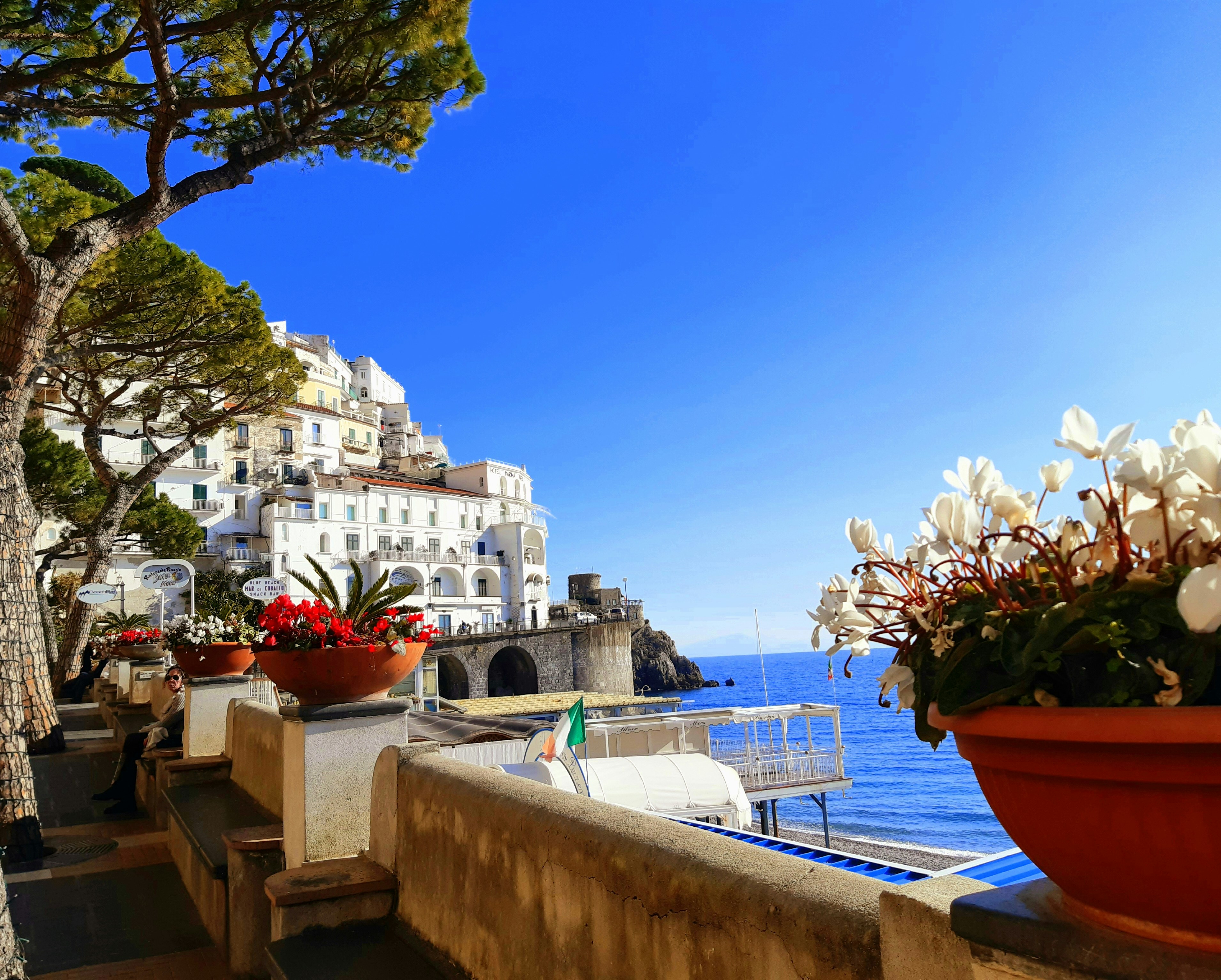 A picture of the white concrete buildings near the sea during daytime.