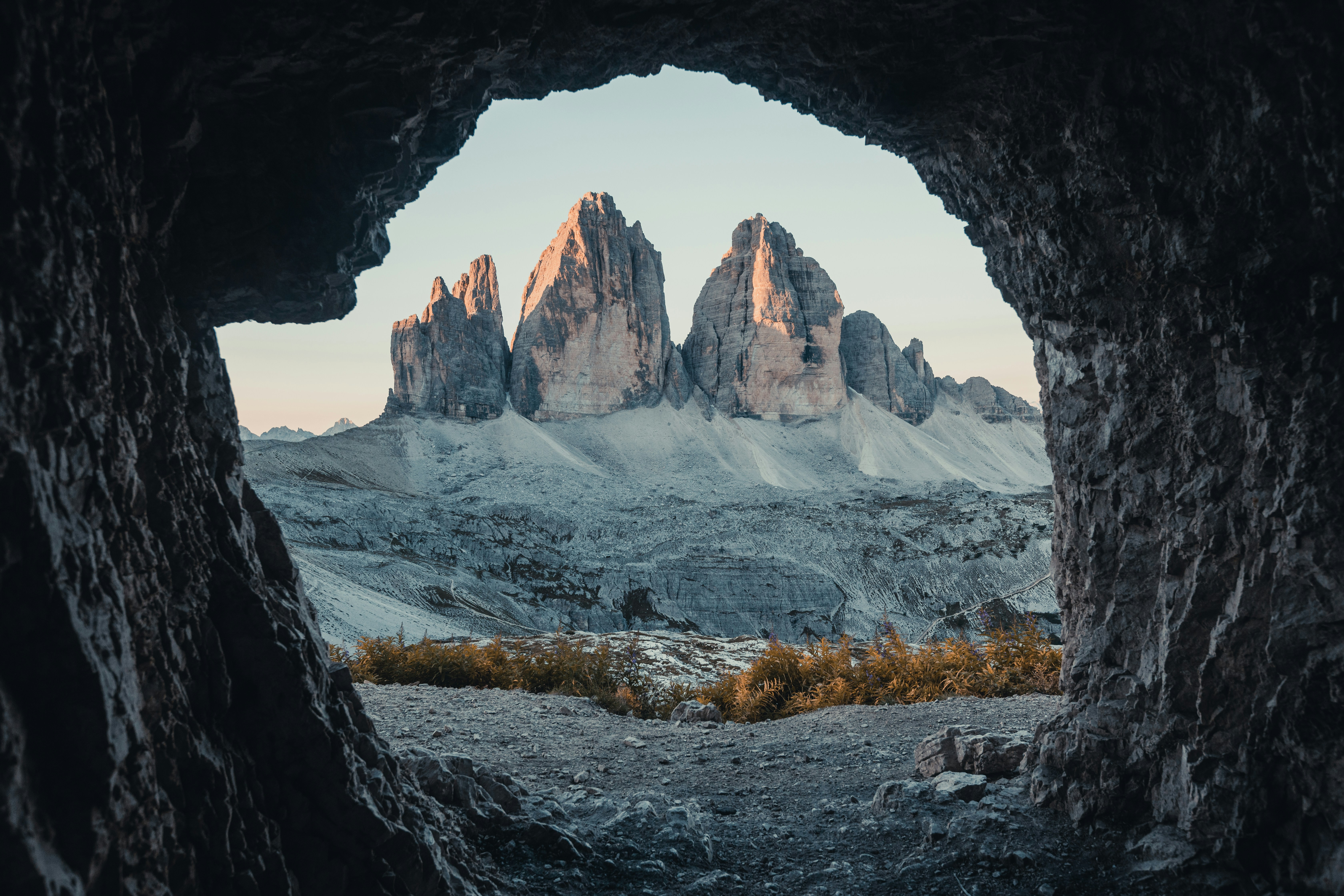 A picture taken from a cave opening of a brown and gray rock formation during daytime.