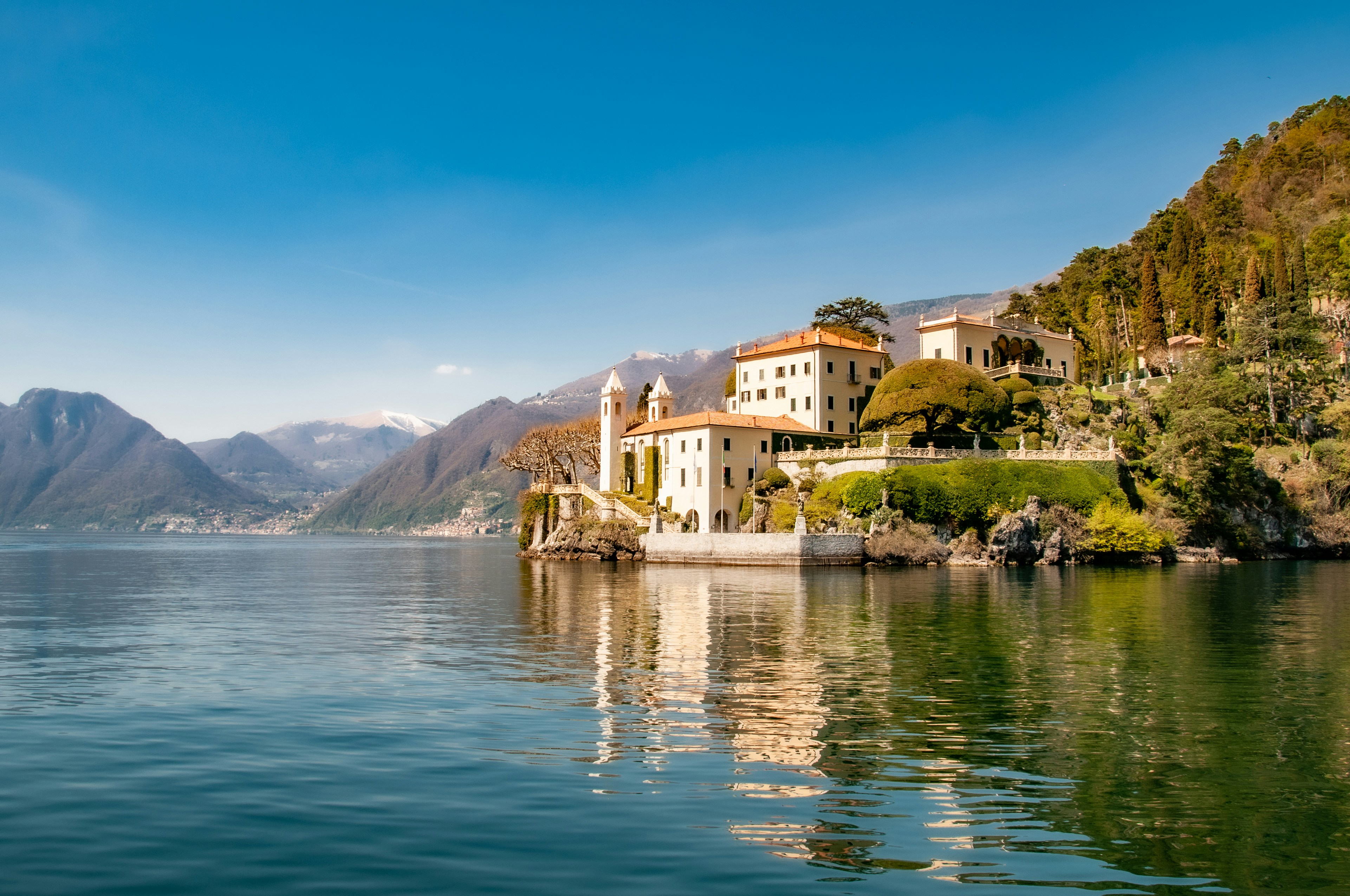 A picture of white concerete building near water during daytime